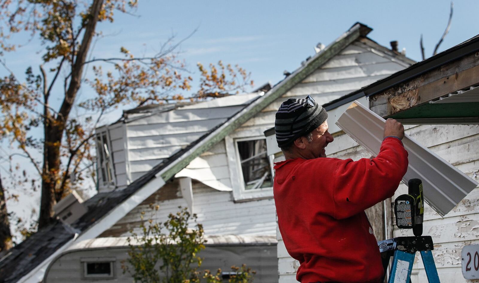 Jim Day repairs his Harrison Twp. rental house damaged by the EF4 tornado that also knocked the house next door from its foundation. CHRIS STEWART / STAFF