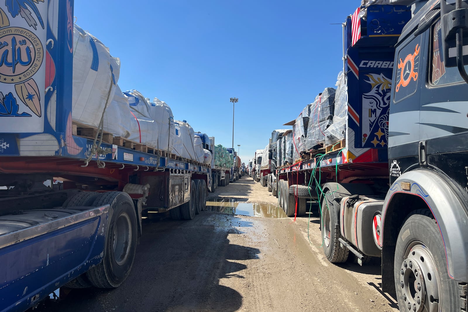 Trucks line up at the Egyptian side of the Rafah border crossing between Egypt and the Gaza Strip after Israel blocked the entry of aid trucks into Gaza, Sunday, March 2, 2025. (AP Photo/Mohamed Arafat)