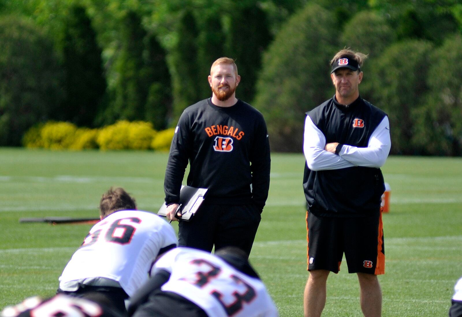 Former Cincinnati Bengals kicker Shayne Graham (left) and special teams coordinator Darrin Simmons oversee stretching at rookie camp Saturday. Jay Morrison/Staff