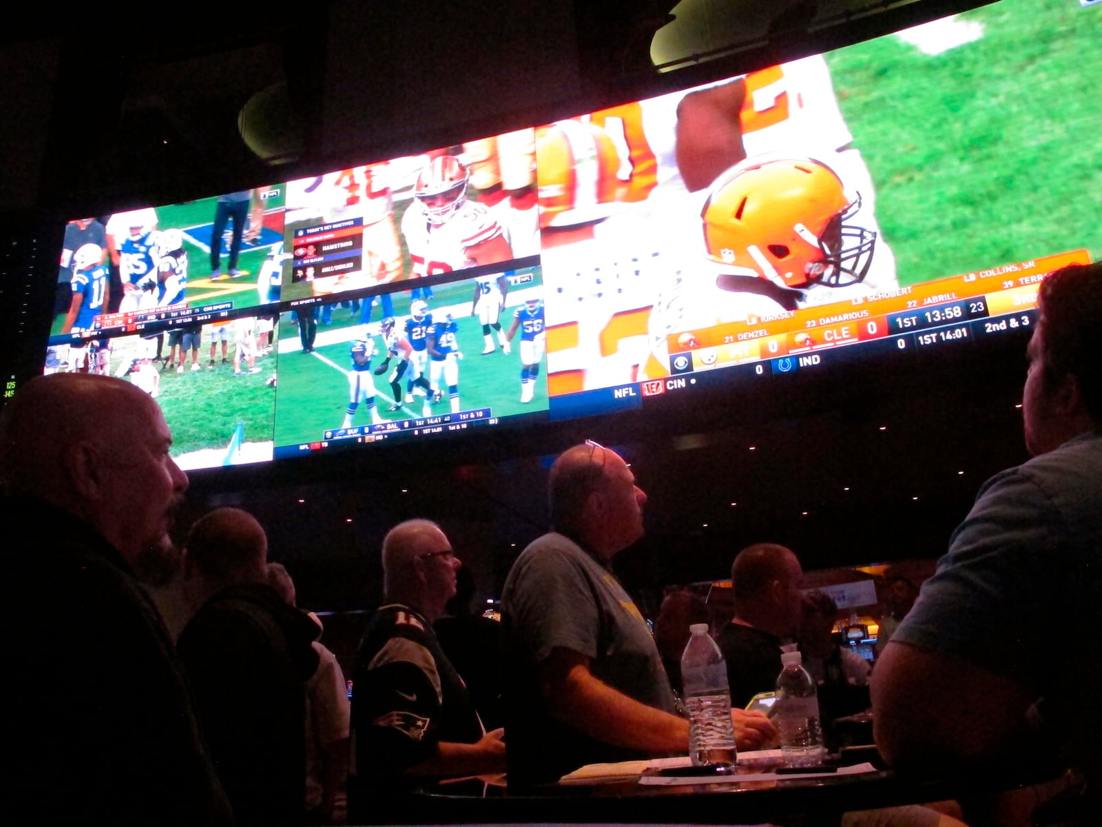 Customers watch an NFL game in the sports betting lounge at the Ocean Resort Casino in Atlantic City N.J. on Sept. 9, 2018. The coronavirus outbreak has added new wrinkles for bettors this year, but even so, the nation's sportsbooks expect a record year of bets on football in 2020 from an antsy public that has been cooped up for months amid the pandemic. (AP Photo/Wayne Parry)