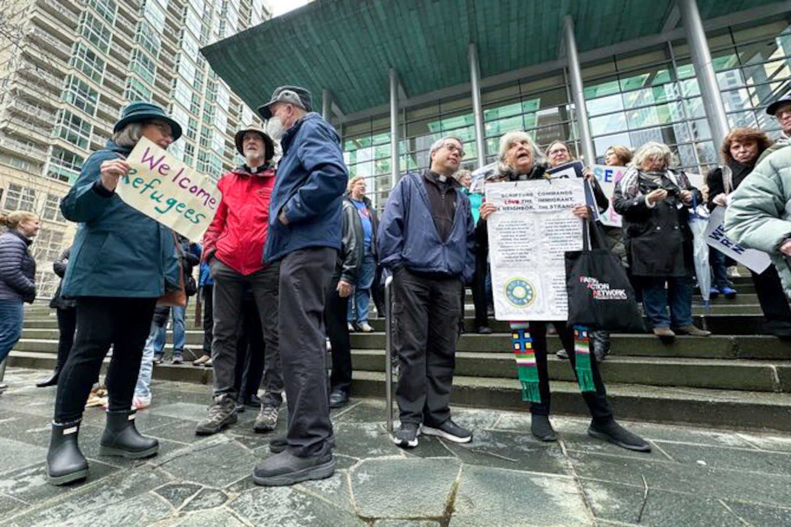 People gather outside the U.S. District Court after a federal judge blocked President Donald Trump's effort to halt the nation's refugee admissions system Tuesday, Feb. 25, 2025, in Seattle. (AP Photo/Eugene Johnson)