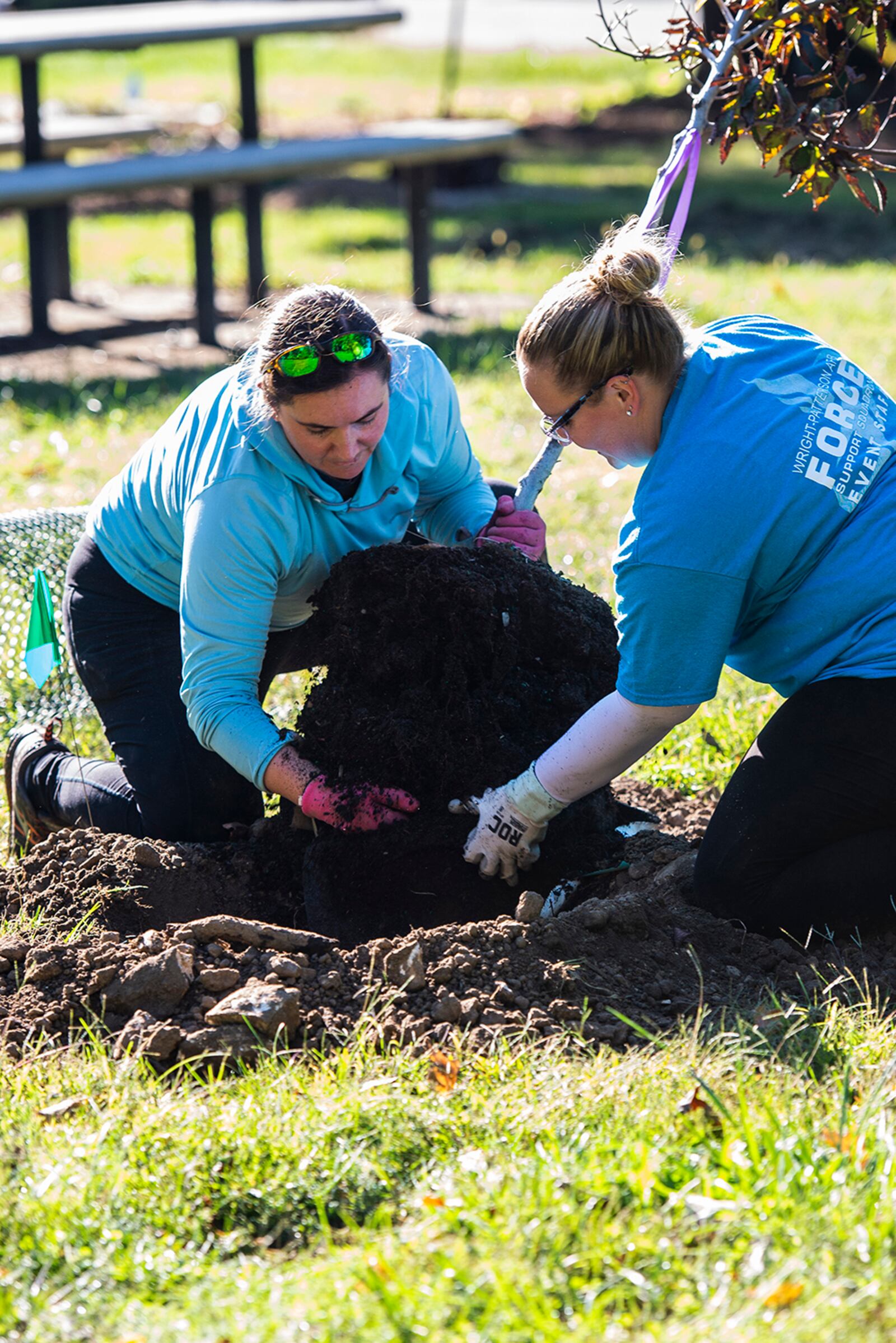 Kaley Bartosik (left) and Sarah Burkhart, both with the 88th Force Support Squadron, place a tree in the ground Oct. 1 at the Wright Brothers Memorial. U.S. AIR FORCE PHOTO/WESLEY FARNSWORTH