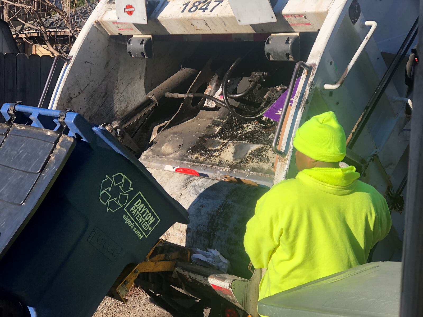 A sanitation worker picks up recycling in Dayton. CORNELIUS FROLIK / STAFF