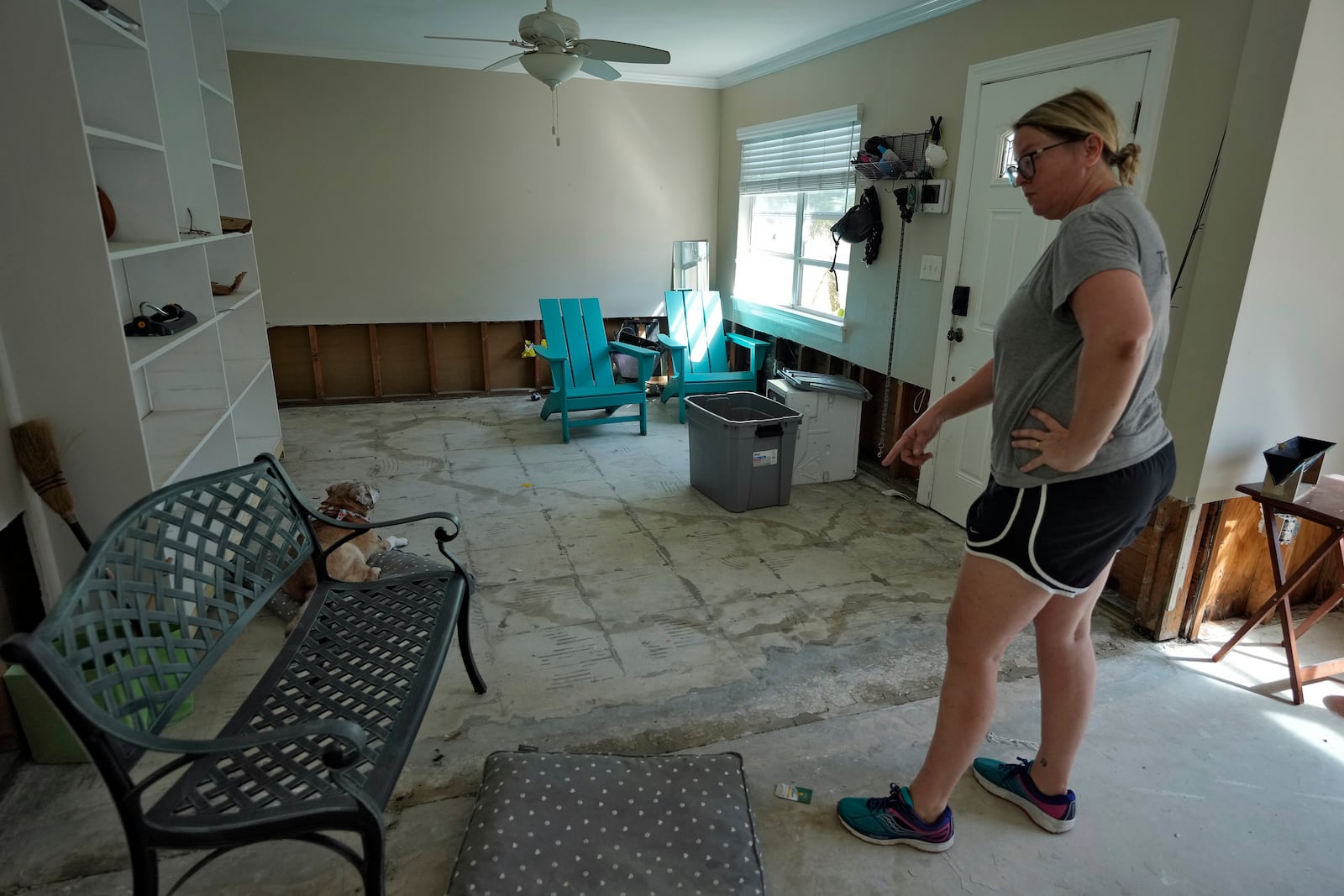 Kat Robinson-Malone points to where flood waters from the effects of Hurricane Milton seeped through their floor's foundation Sunday, Oct. 13, 2024, in Tampa, Fla. (AP Photo/Chris O'Meara)