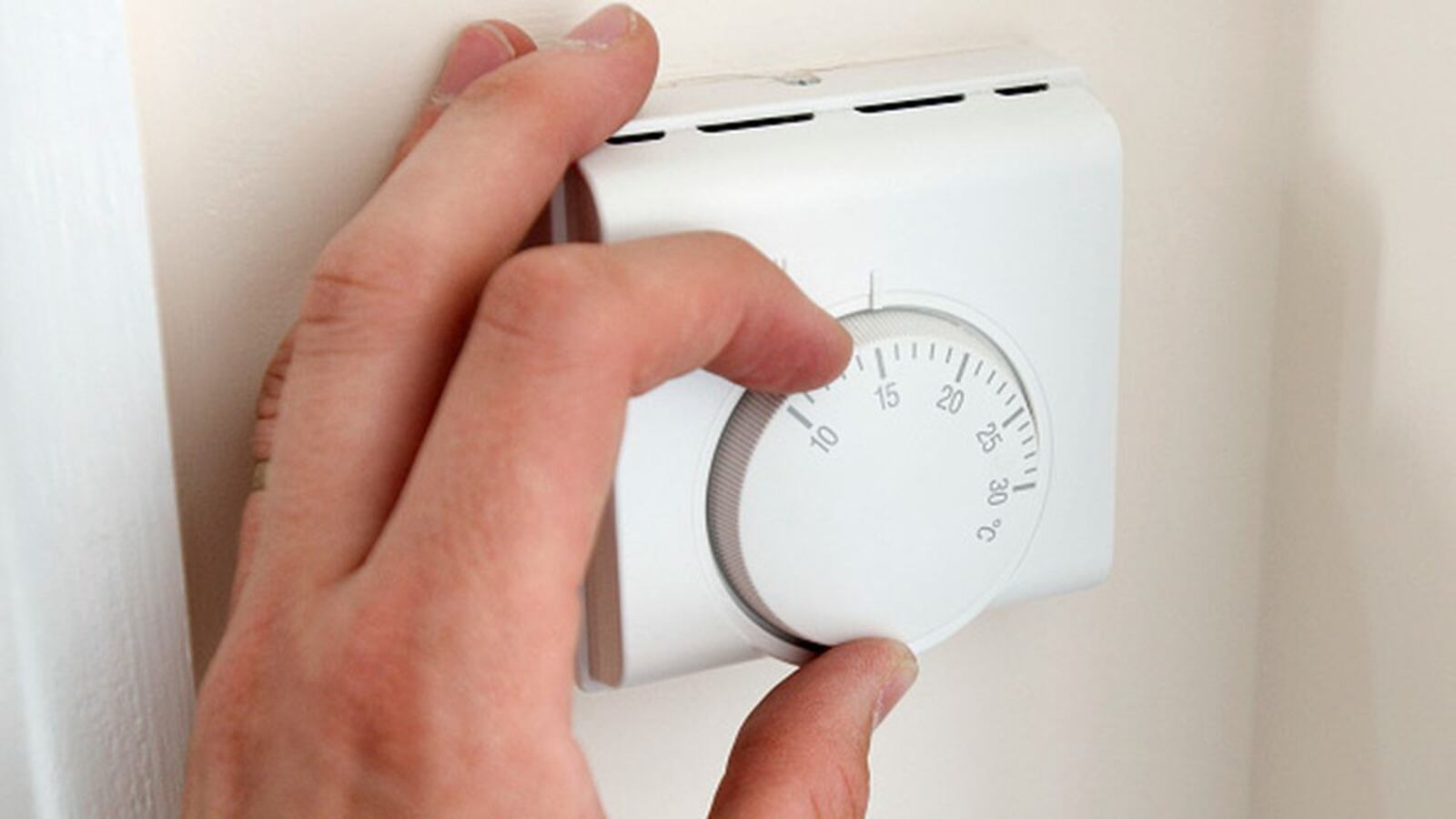 Person adjusting thermostat. (Photo by BuildPix/Construction Photography/Avalon/Getty Images) (Construction Photography/Avalon/Getty Images)