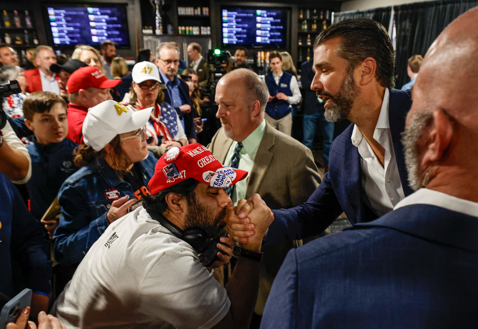 A man kisses the hand of Donald Trump Jr. as he greets supporters after a town hall meeting Monday, March 17, 2025, in Oconomowoc, Wis. (AP Photo/Jeffrey Phelps)