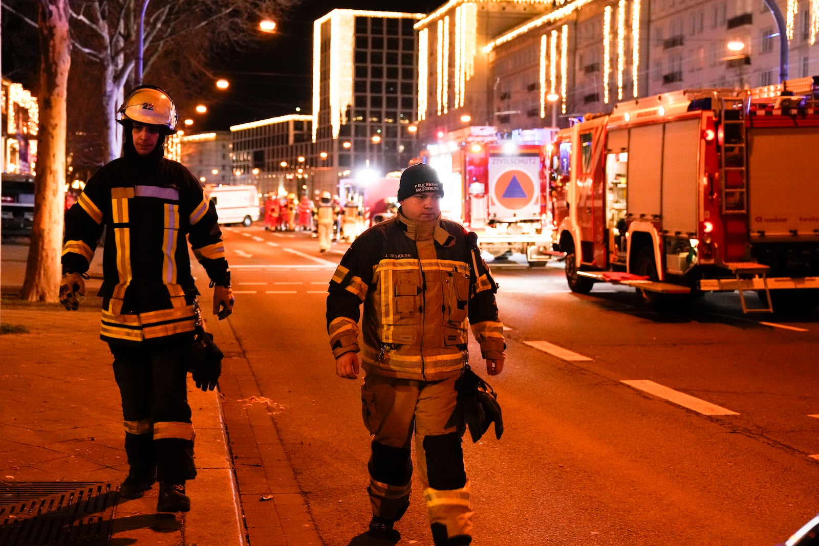 Two firefighters walk through a cordoned-off area near a Christmas Market, after a car drove into a crowd in Magdeburg, Germany, Saturday, Dec. 21, 2024. (AP Photo/Ebrahim Noroozi)