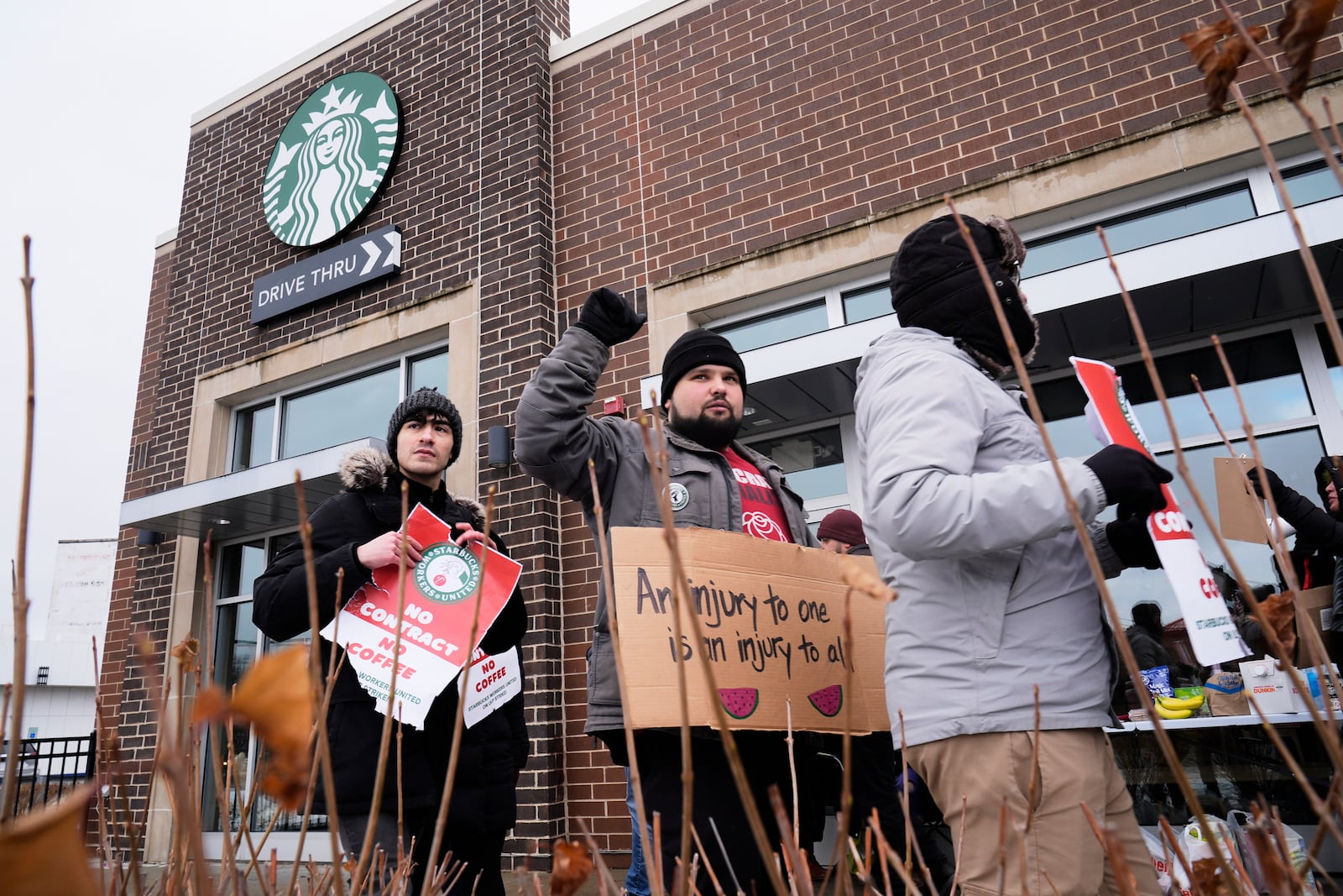 Employees picket outside a Starbucks store, Friday, Dec 20, 2024, in Chicago. (AP Photo/Kiichiro Sato)