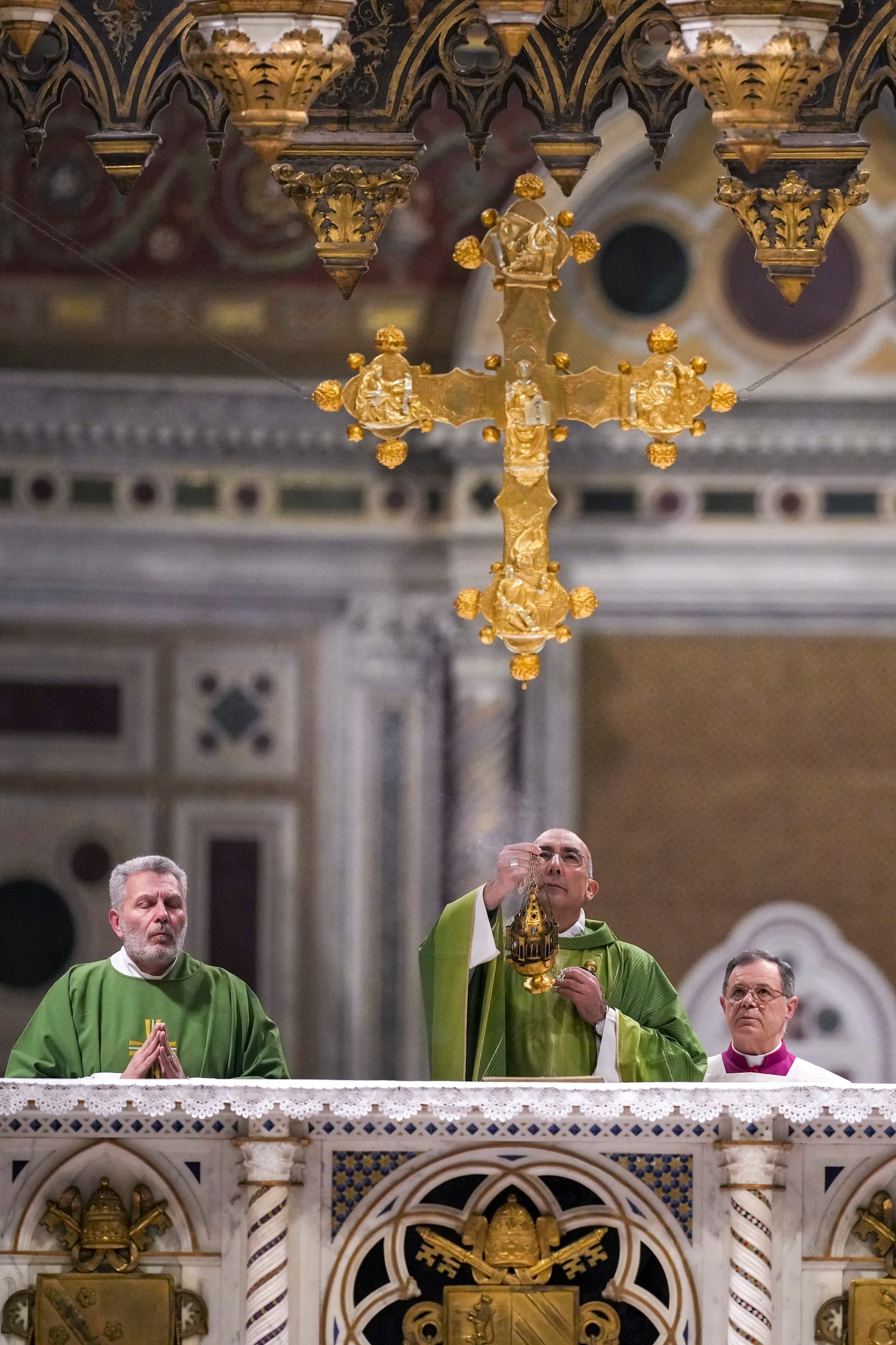 Pope's vicar general of the Diocese of Rome, Cardinal Baldassarre Reina, center, celebrates mass in St. John Lateran Basilica in Rome Sunday, Feb. 23, 2025, to pray for Pope Francis who was admitted over a week ago at Rome's Agostino Gemelli Polyclinic and is in critical condition. (AP Photo/Alessandra Tarantino)