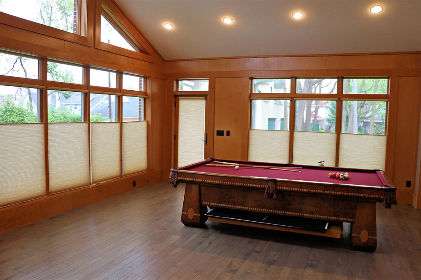 Off the kitchen, the recreation room addition has a contemporary flair with laminate wood-plank flooring, vaulted ceiling, canister lighting and a ceiling fan.