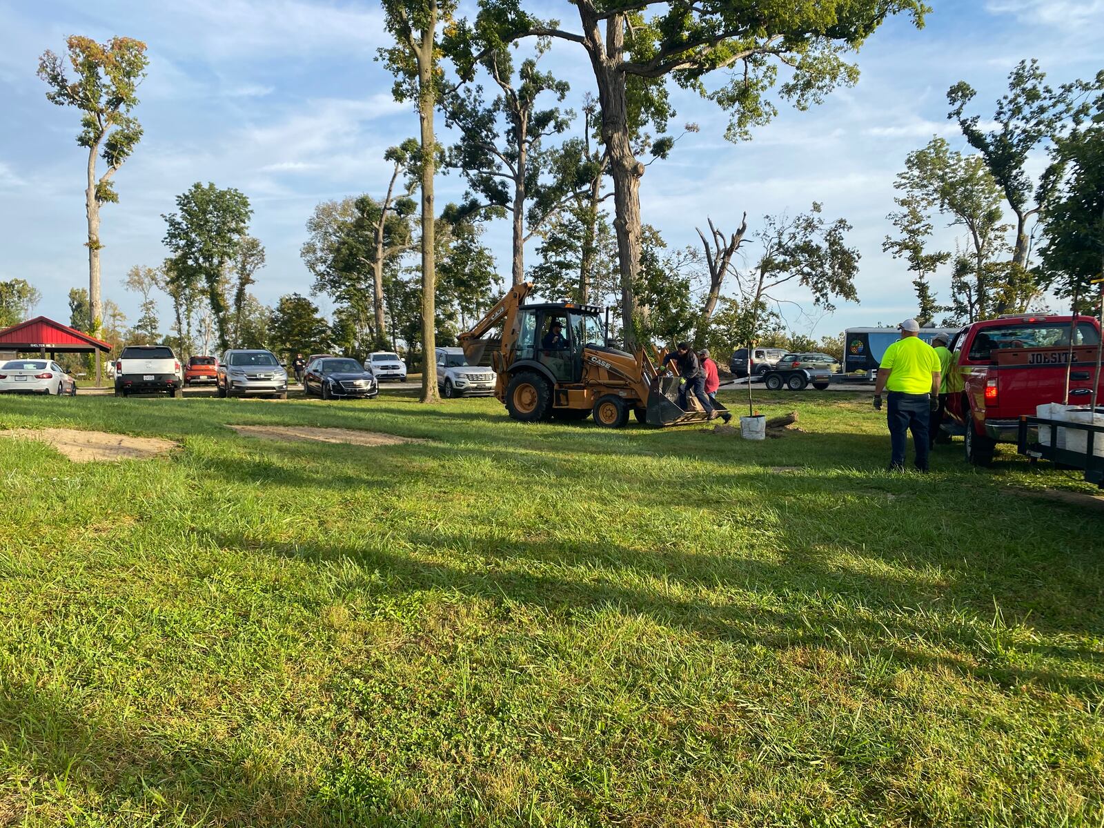 Harrison Twp. workers move the trees that will be planted at Sinclair Park Saturday. In the background, some of the mature trees that were not destroyed by the 2019 Memorial Day tornado. Eileen McClory / Staff