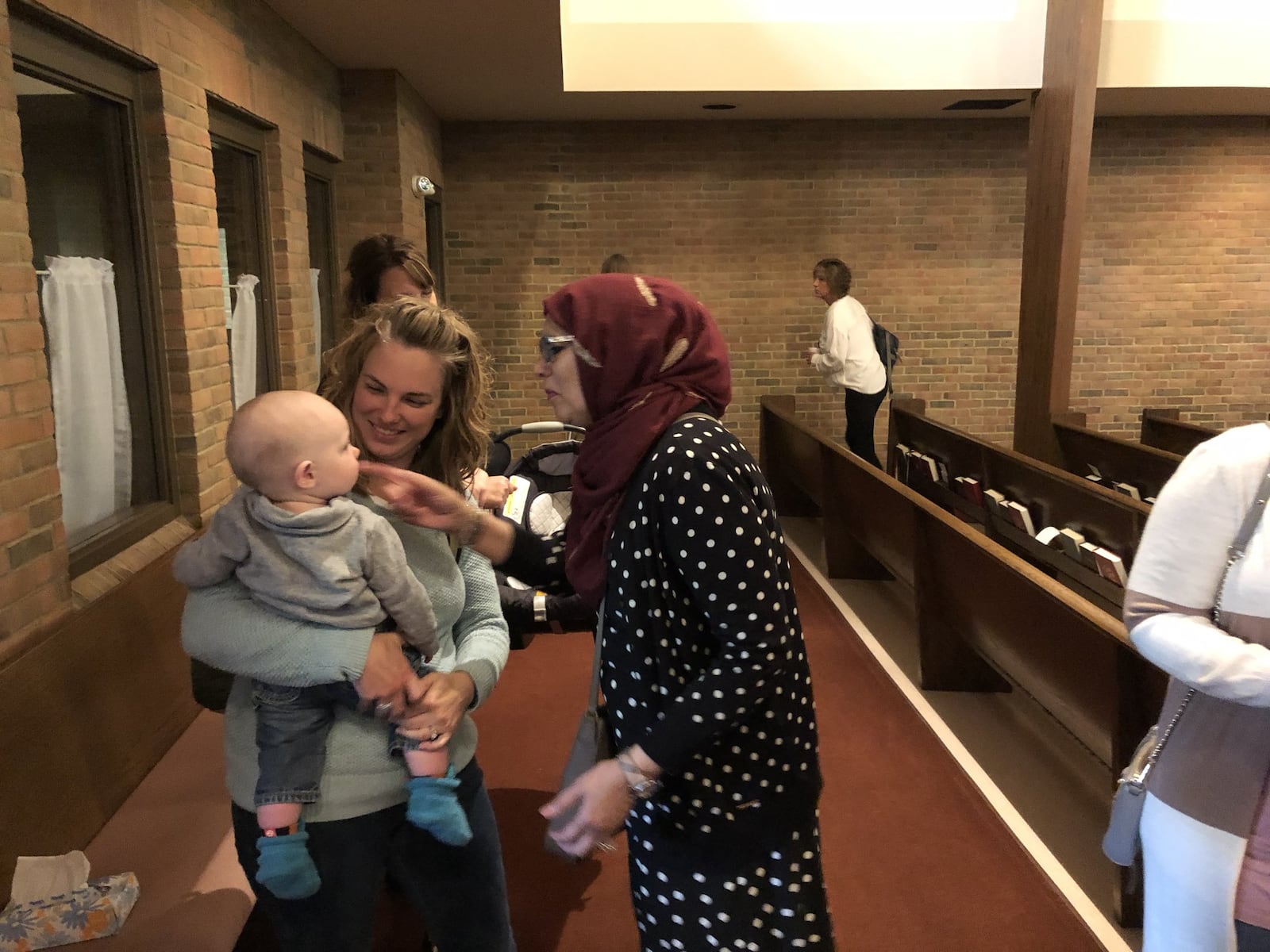 Samina Ahmed of Masjid Al-Madina Mosque, right, greets Central Christian Church member Stephanie Ison and son William following a Sunday service in which the Muslim community supported the church. Photo by Brett Turner