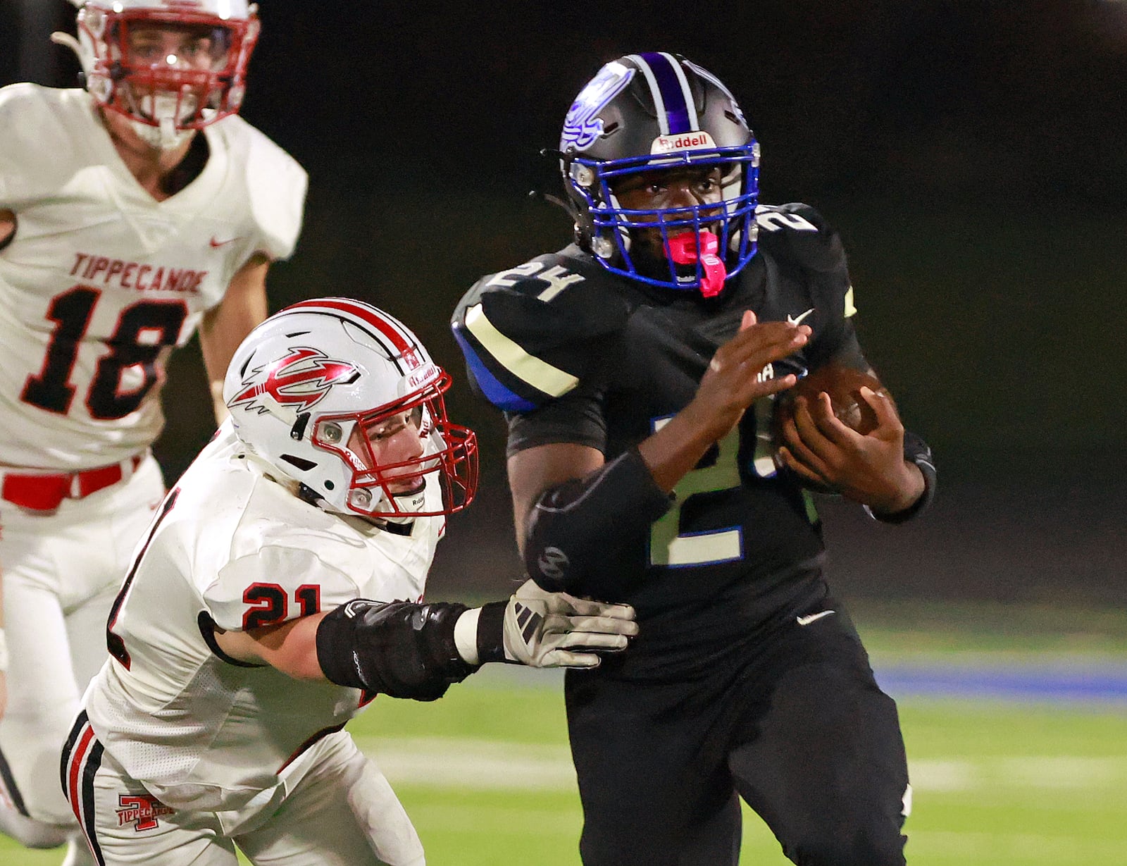 Xenia's Deaunte White avoids a tackle by Tipp's Collin Isaac as he carries the ball. BILL LACKEY/STAFF