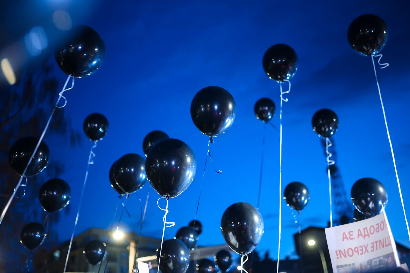 People taking part in a protest hold balloons in the town of Kocani, North Macedonia, Tuesday, March 18, 2025 following a massive fire in a nightclub early SUnday. (AP Photo/Armin Durgut)