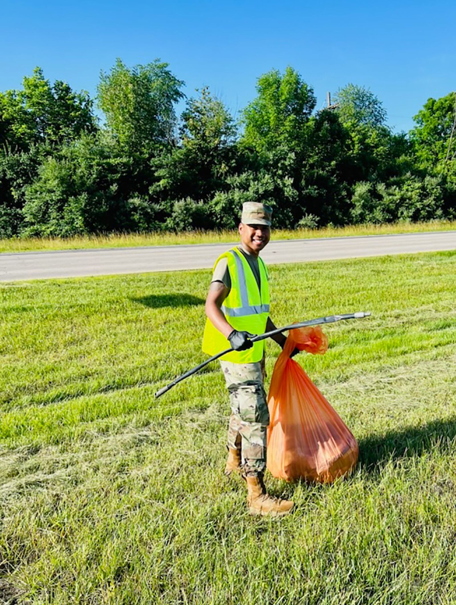 Tech. Sgt. Randolph Koram, National Air and Space Intelligence Center volunteer coordinator, picks up litter June 16 on the roads outside Wright-Patterson Air Force Base. NASIC Airmen partnered with the Ohio Department of Transportation via the Adopt-A-Highway program to celebrate Father’s Day and Juneteenth. CONTRIBUTED PHOTO