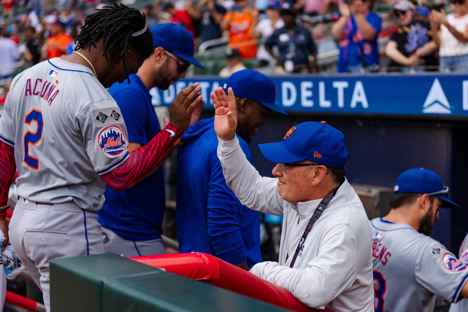 FILE - New York Mets owner, Steve Cohen, right, high fives Luisangel Acuña in the dugout after winning the game in the ninth inning of a baseball game against the Atlanta Braves, Monday, Sept. 30, 2024, in Atlanta. (AP Photo/Jason Allen, FIle)