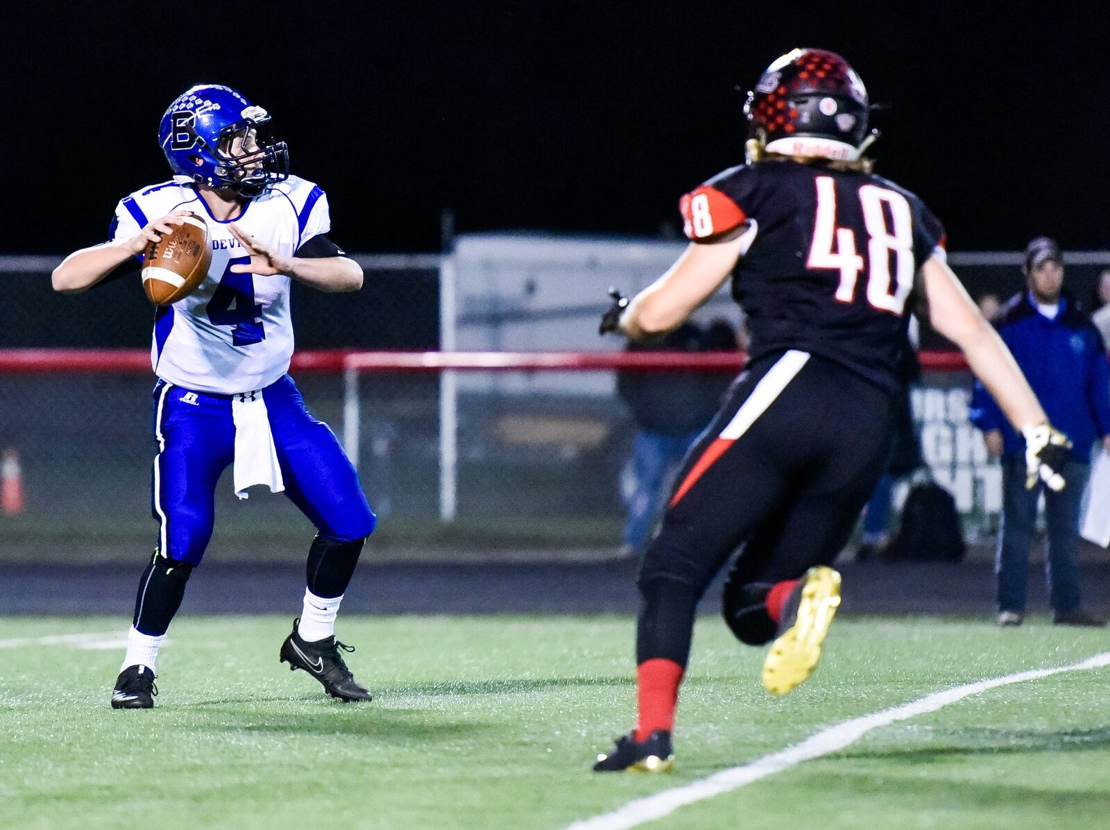 Franklin’s Logan Clark (48) makes a run at Brookville quarterback Mason Stout during Thursday night’s game at Atrium Stadium in Franklin. NICK GRAHAM/STAFF