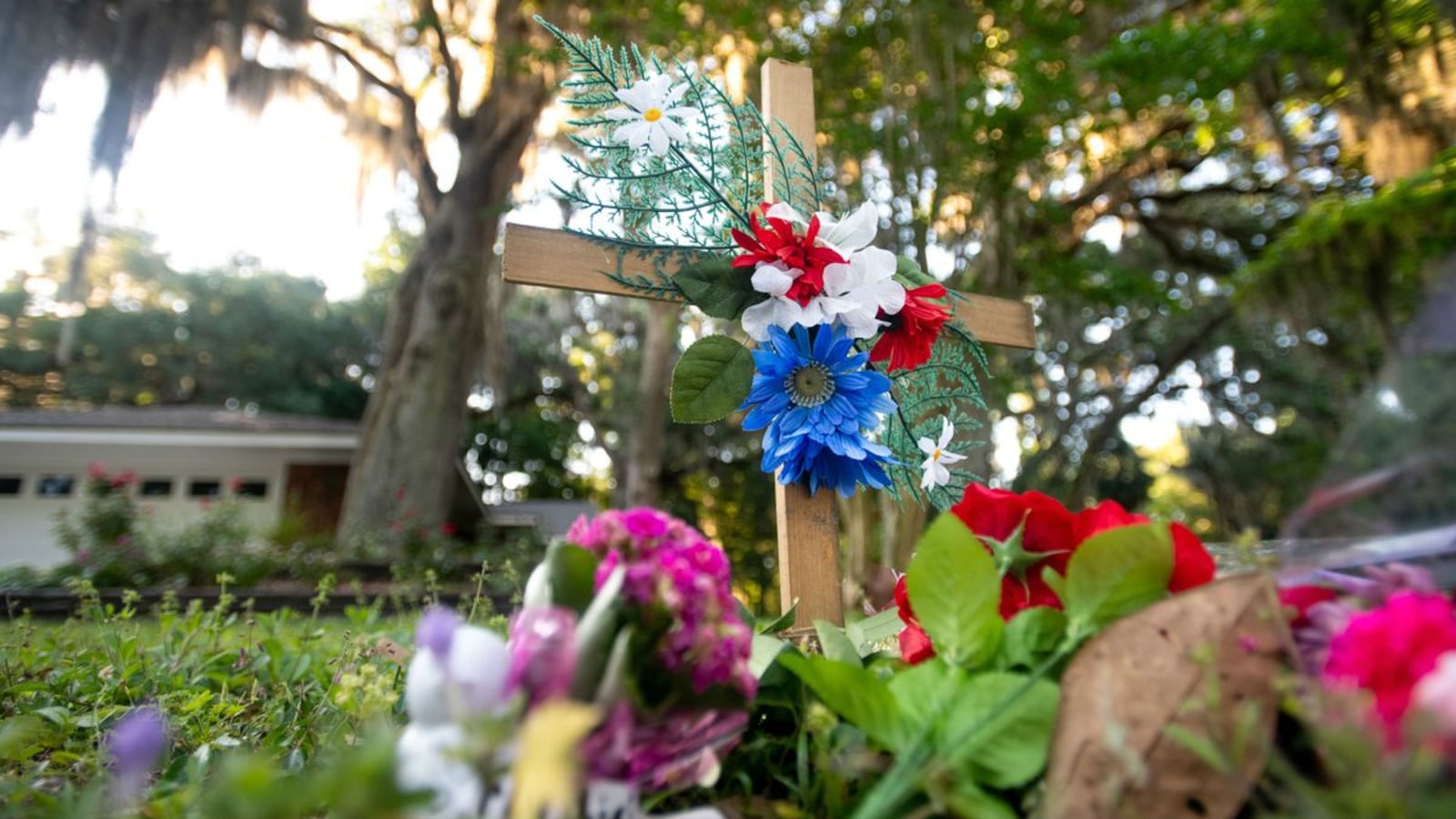 A cross and flowers are seen Thursday, May 7, 2020, near the intersection where black jogger Ahmaud Arbery was gunned down Feb. 23 in the Satilla Shores neighborhood of Brunswick, Ga. Travis McMichaels, 34, and his father, Gregory McMichaels, 64, are charged with felony murder and aggravated assault in the shooting, which was caught on video. (Sean Rayford/Getty Images)