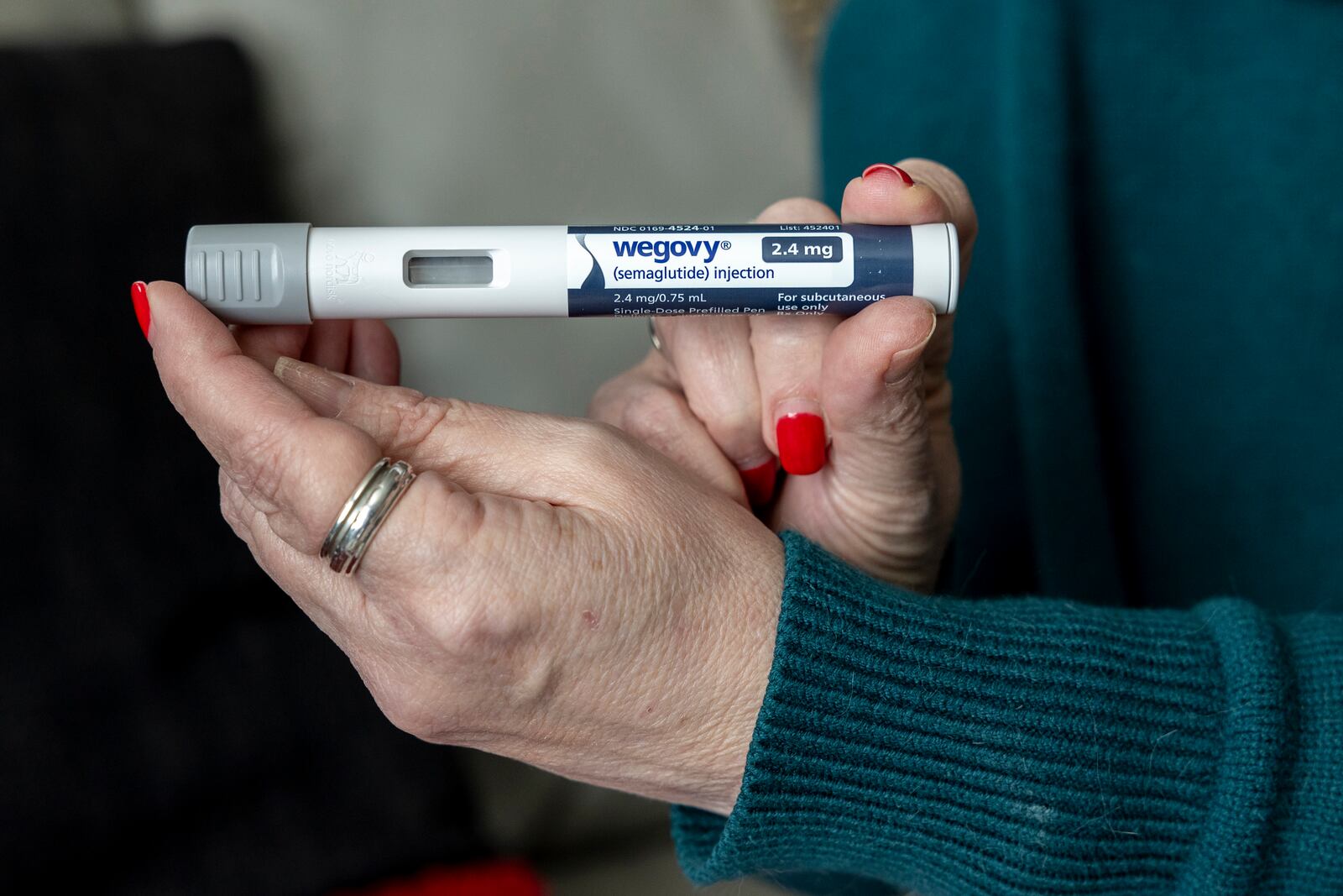 FILE - A woman holds up a dosage of Wegovy, a drug used for weight loss, at her home in Front Royal, Va., on March 1, 2024. (AP Photo/Amanda Andrade-Rhoades, File)