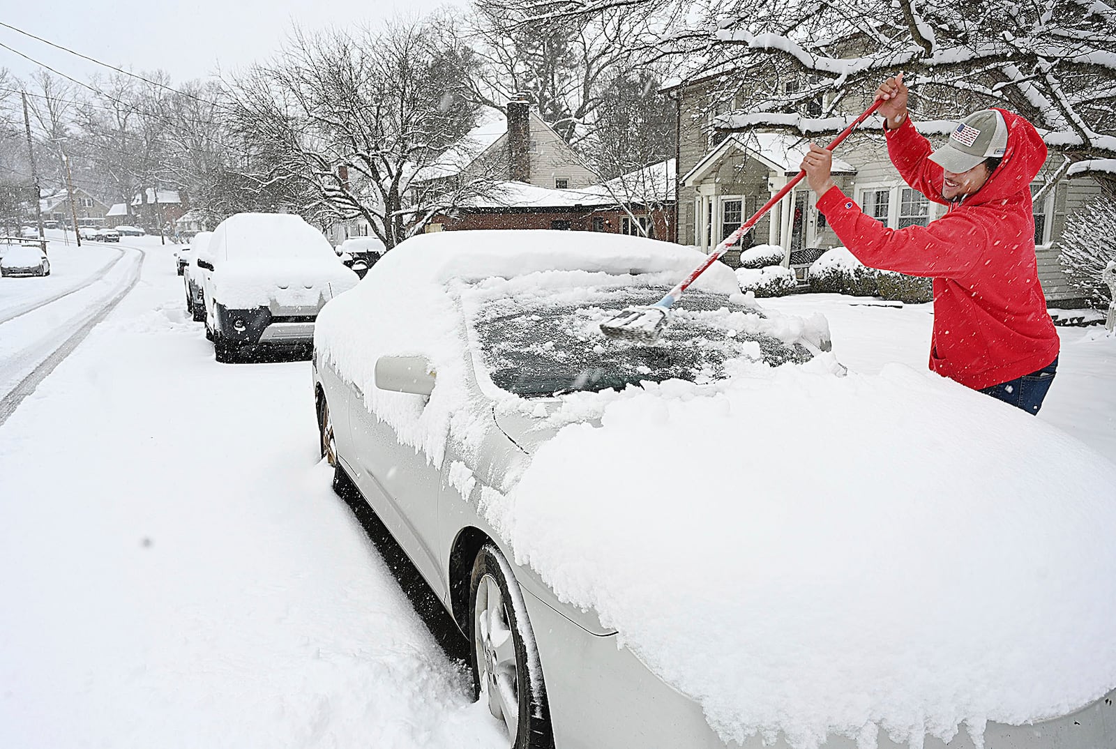 Christian Lively sweeps snow off his car in front of his house on Woodlawn Ave in Beckley, W.Va., Tuesday, Feb. 11, 2025. (Rick Barbero/The Register-Herald via AP)