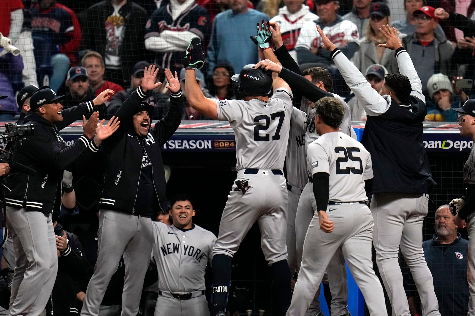 New York Yankees' Giancarlo Stanton (27) celebrates with teammates after hitting a home run against the Cleveland Guardians during the eighth inning in Game 3 of the baseball AL Championship Series Thursday, Oct. 17, 2024, in Cleveland.(AP Photo/Jeff Roberson)