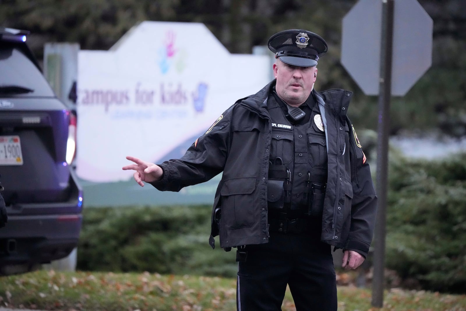 A police officer directs traffic as emergency vehicles are parked outside the Abundant Life Christian School in Madison, Wis., where multiple injuries were reported following a shooting, Monday, Dec. 16, 2024. (AP Photo/Morry Gash)