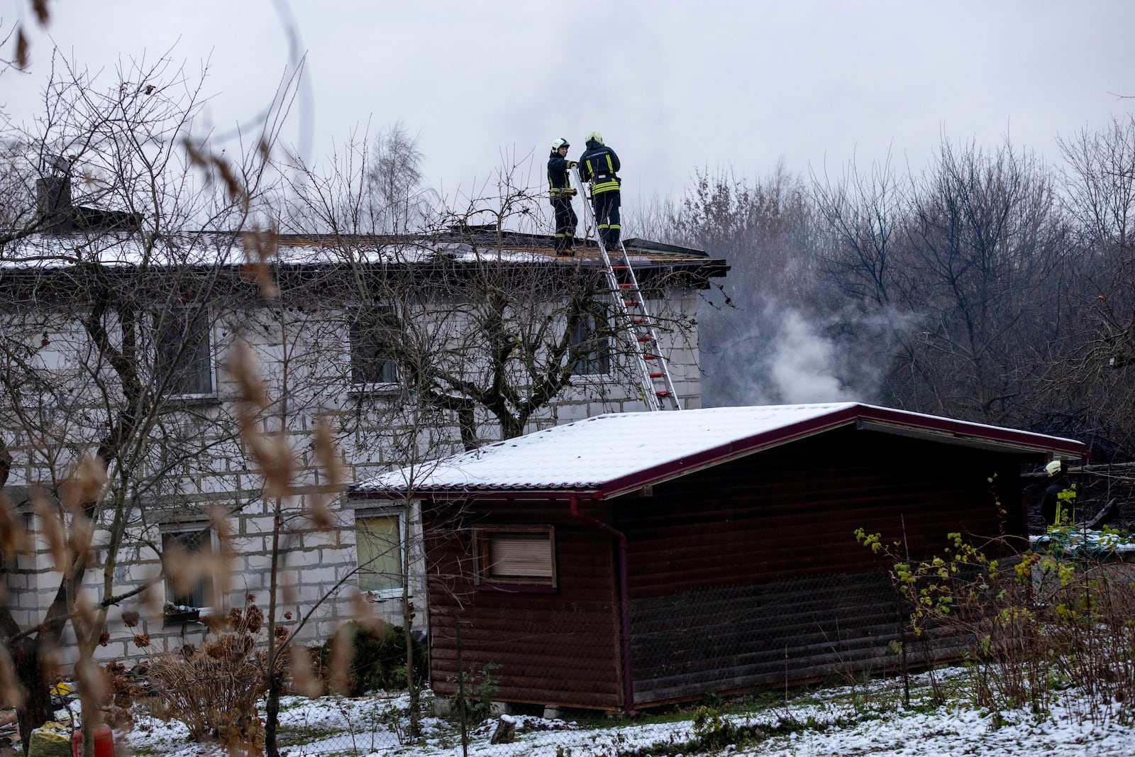 Lithuanian Emergency Ministry employees work near the place where a DHL cargo plane crashed into a house near the Lithuanian capital Vilnius, Lithuania, Lithuania, Monday, Nov. 25, 2024. (AP Photo/Mindaugas Kulbis)