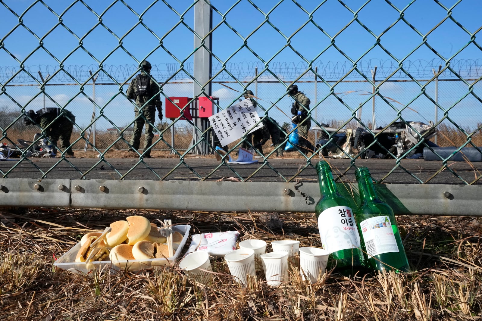 A message of condolences and foods are seen outside of Muan International Airport in Muan, South Korea, Tuesday, Dec. 31, 2024, following Sunday's plane crash. (AP Photo/Ahn Young-joon)