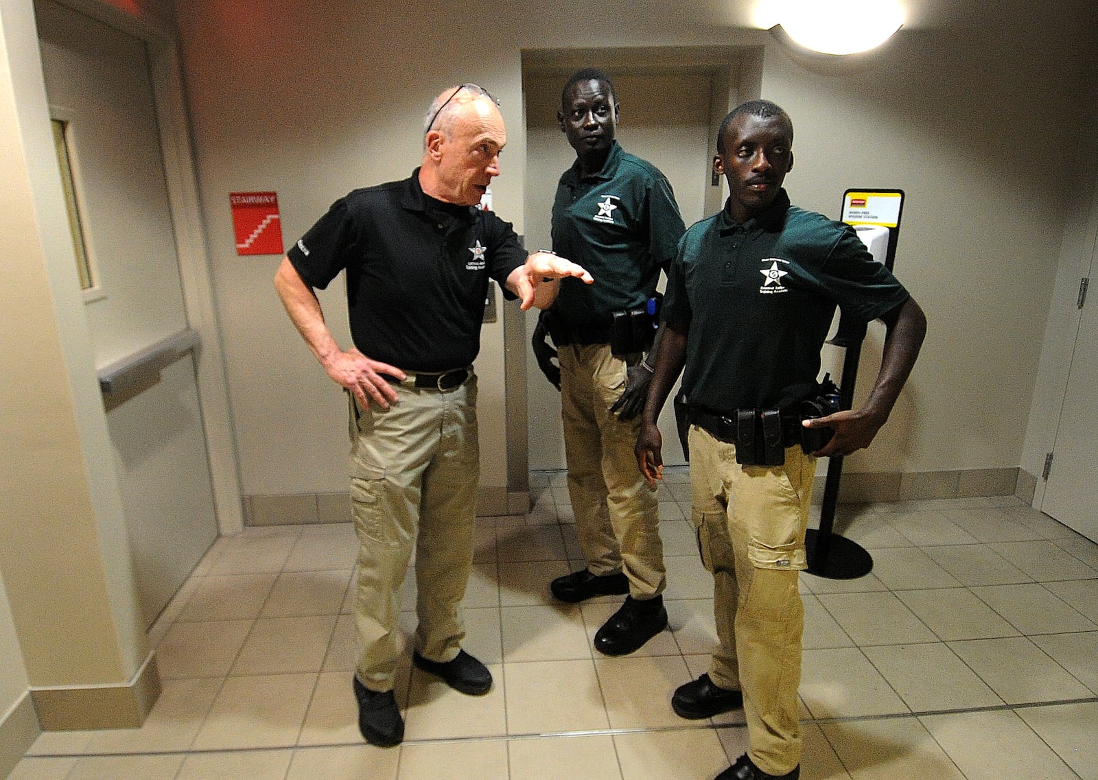 Retired Chief David Miller (left) briefs cadets Chol Chol (center) and Fidele Ngabo (right) on a building search drill, April 30, 2024. MARSHALL GORBY/STAFF