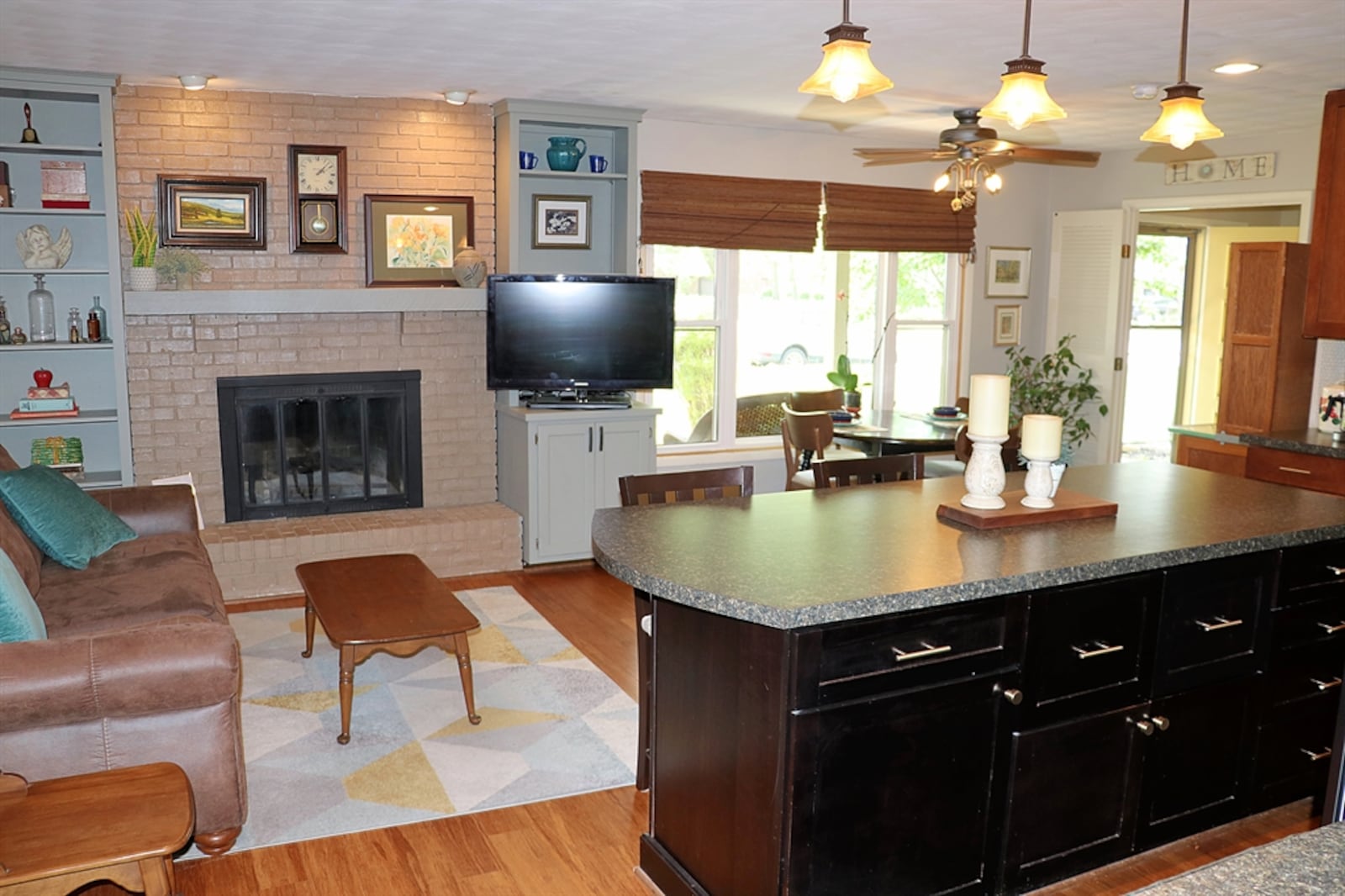 The brick fireplace has a raised brick hearth and wood-beam mantel. 