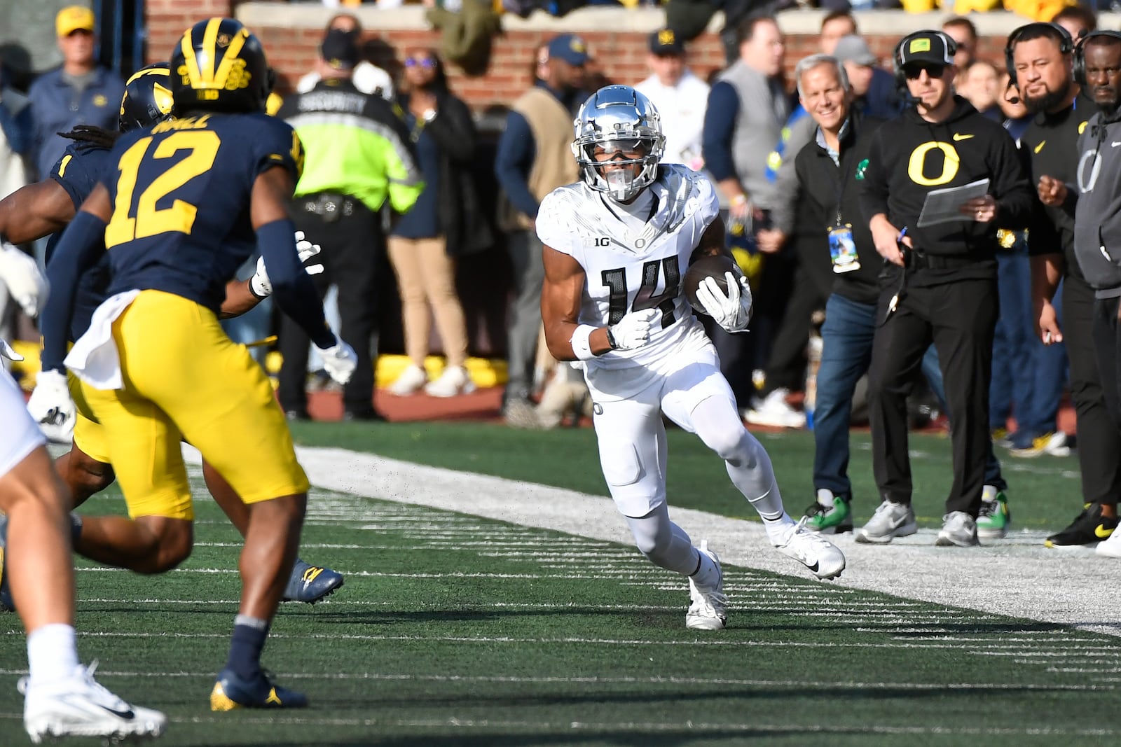 Oregon wide receiver Justius Lowe (14) runs with the ball as Michigan defensive back Aamir Hall (12) chases him during the first half of an NCAA college football game, Saturday, Nov. 2, 2024, in Ann Arbor, Mich. (AP Photo/Jose Juarez)