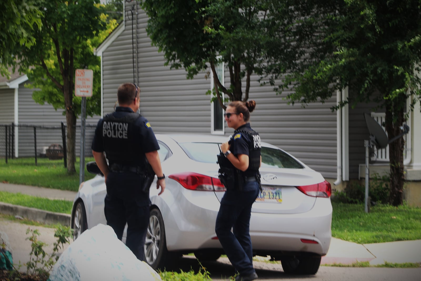 Two Dayton police officers examine an empty Hyundai that was parked in the middle of the street at the intersection of Steele Avenue and Clover Street on at 2:15 p.m. Friday, Aug. 11, 2023. Thieves have been targeting Hyundai and Kia vehicles because they have a security flaw that makes them easy to steal. CORNELIUS FROLIK / STAFF