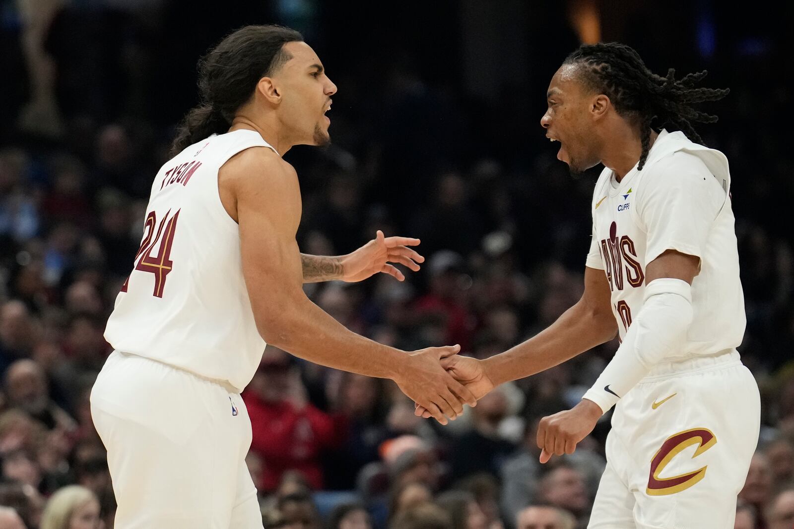 Cleveland Cavaliers forward Jaylon Tyson, left, celebrates with teammate Darius Garland, right, after shooting a 3-point basket in the first half of an NBA basketball game against the Phoenix Suns, Monday, Jan. 20, 2025, in Cleveland. (AP Photo/Sue Ogrocki)