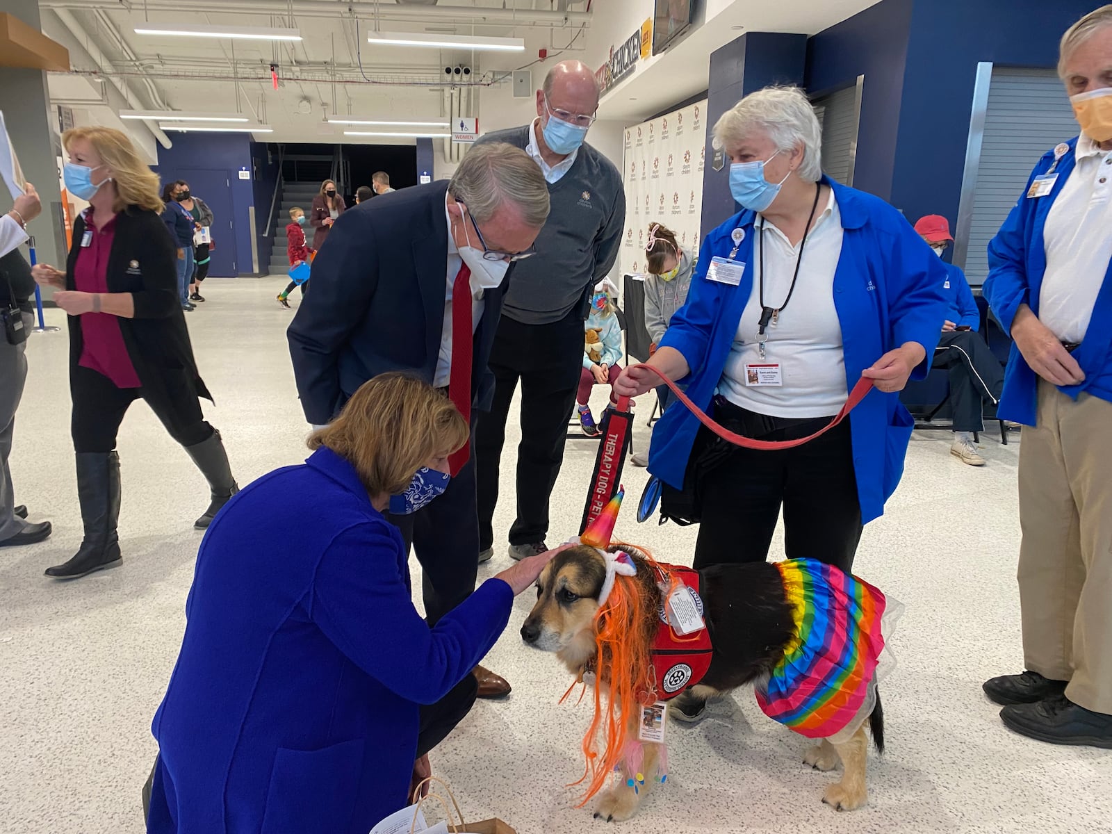 Ohio's First Lady, Fran DeWine, pets Sunny, a therapy dog, on Sunday, as Ohio Governor Mike DeWine, Dr. Adam Mezoff, chief medical officer at Dayton Children's, and Sunny's handler, Karen Loar, look on. Eileen McClory / staff