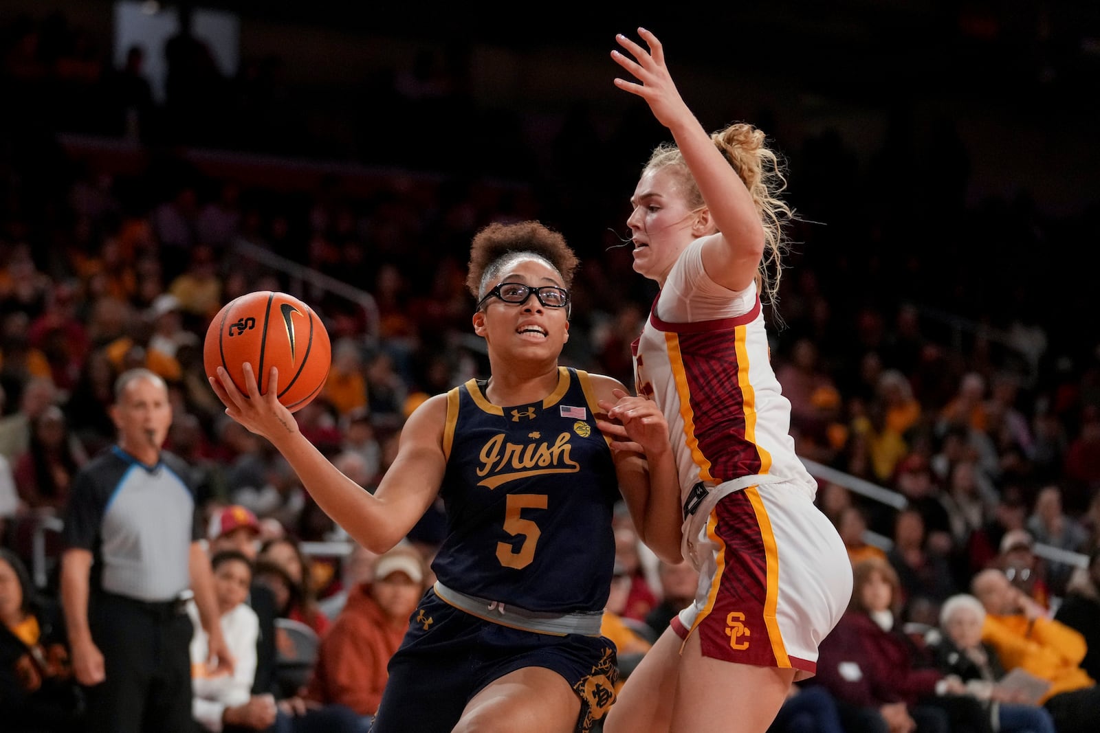 Notre Dame guard Olivia Miles (5) drives against Southern California guard Avery Howell during the first half of an NCAA college basketball game, Saturday, Nov. 23, 2024 in Los Angeles. (AP Photo/Eric Thayer)