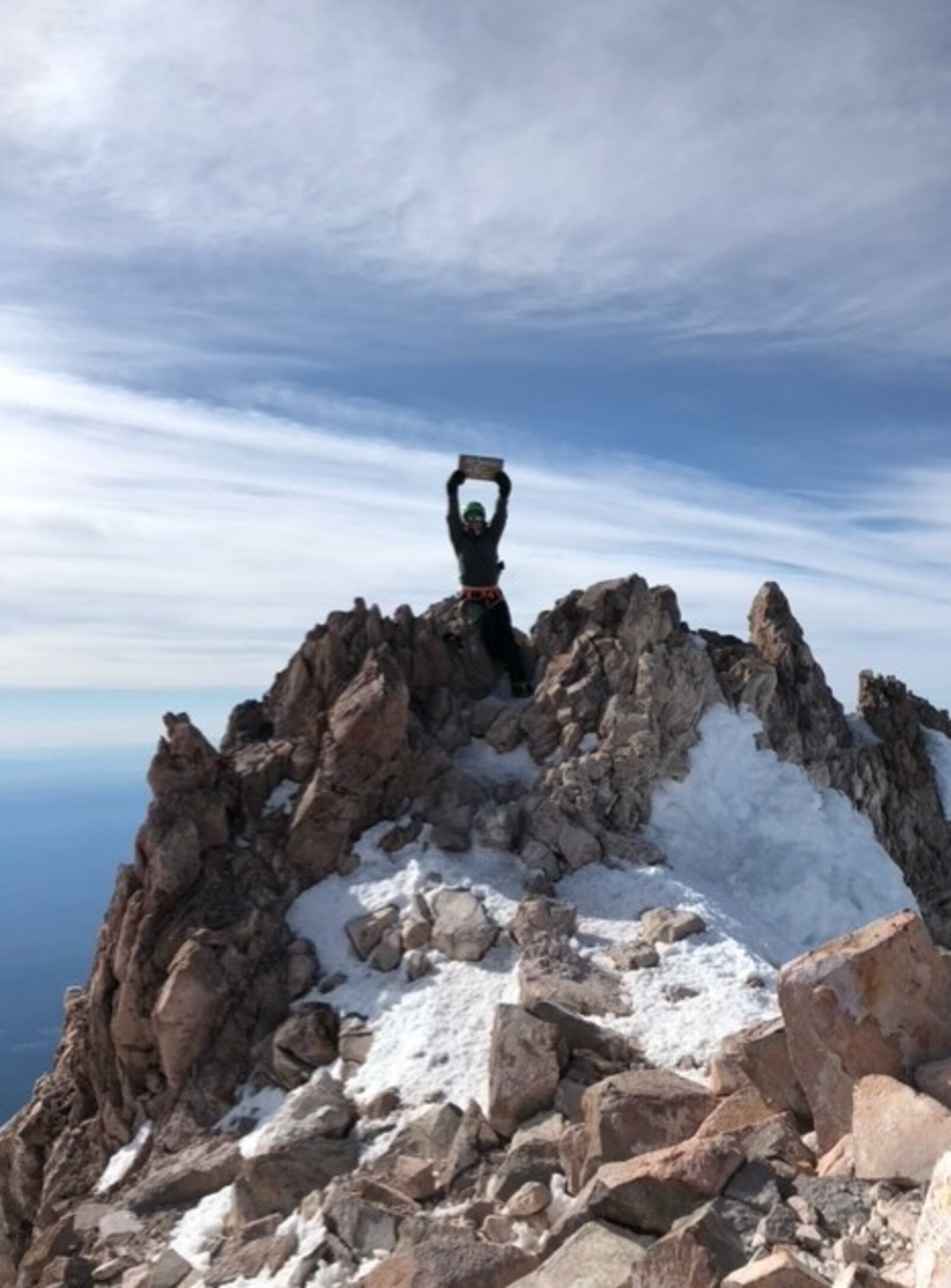 Cheryl Dillin, of Springboro, shows her summit sign at the top of Mount Shasta. CONTRIBUTED