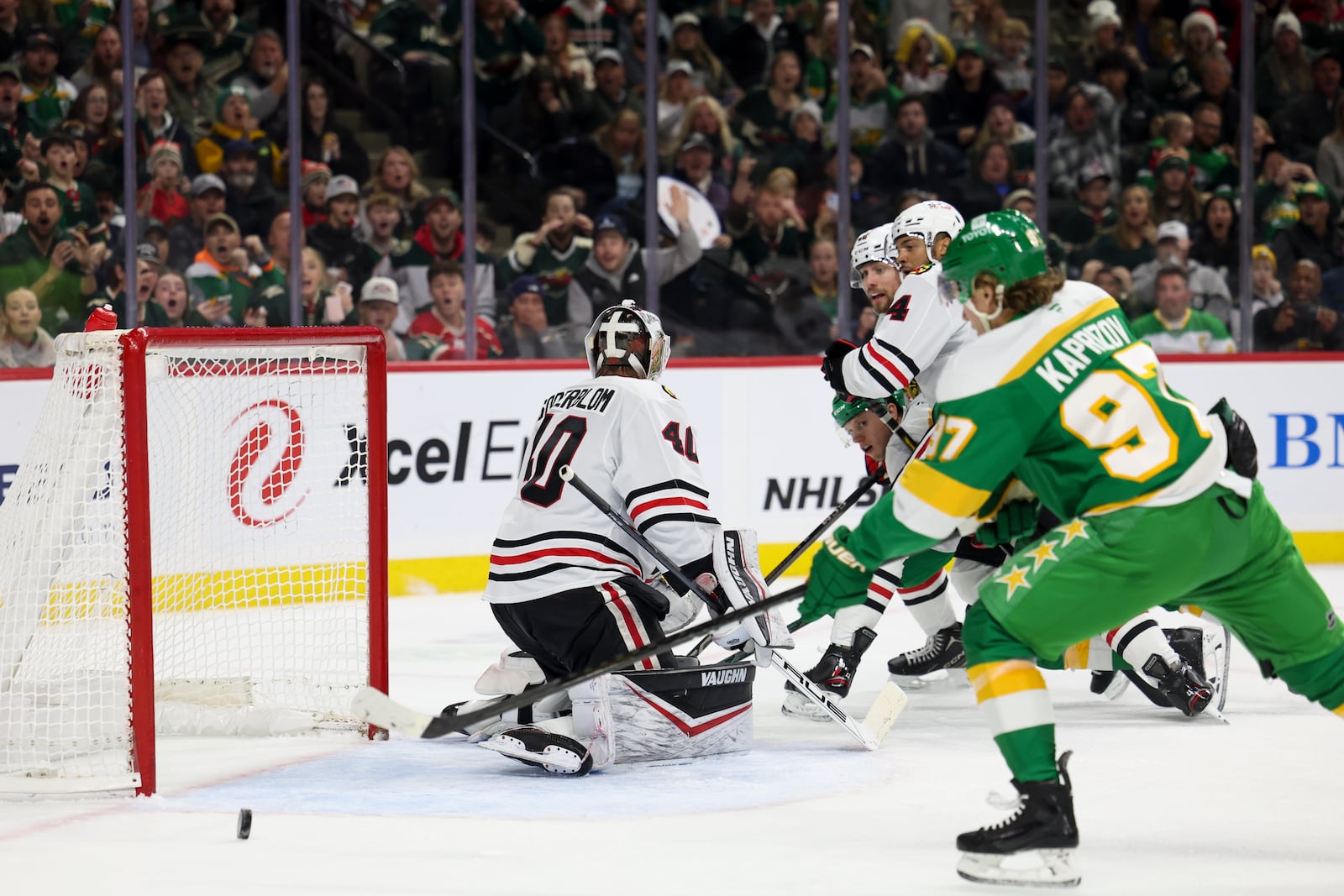 Minnesota Wild left wing Kirill Kaprizov, right, tips the puck into the net for a goal on Chicago Blackhawks goaltender Arvid Soderblom (40) during the first period of an NHL hockey game, Monday, Dec. 23, 2024, in St. Paul, Minn. (AP Photo/Ellen Schmidt)