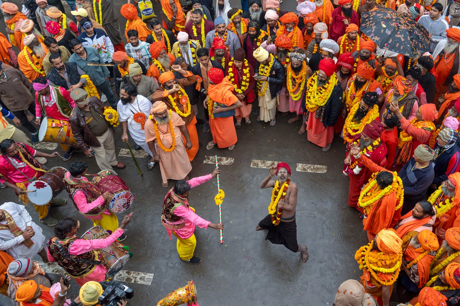 An ascetic dances with another as Hindu holy man walk in a procession, a day before the 45-day-long Maha Kumbh festival, in Prayagraj, India, Sunday, Jan. 12, 2025. (AP Photo/Ashwini Bhatia)