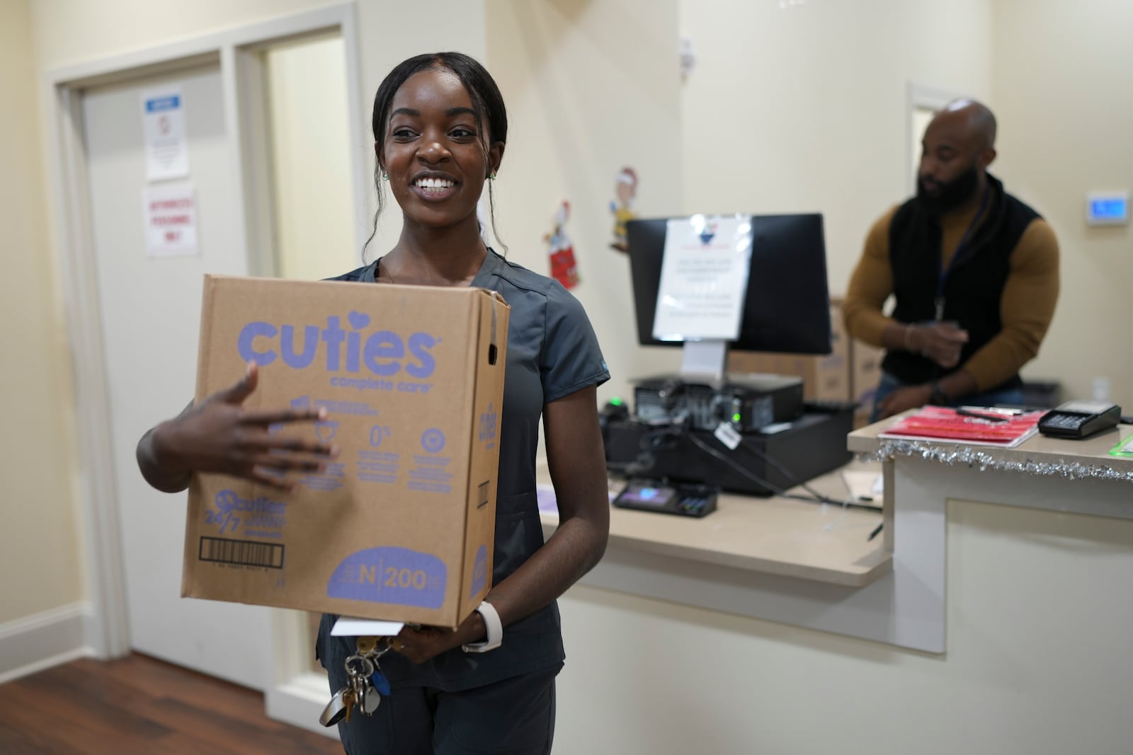 Tatayanna Johnson carries a box of diapers for her child from the Pharmalife Community Pharmacy, Monday, Dec. 9, 2024, in Murfreesboro, Tenn. Johnson participates in the states TennCare Diaper Benefit, which provides free diapers for children under the age of two. (AP Photo/George Walker IV)