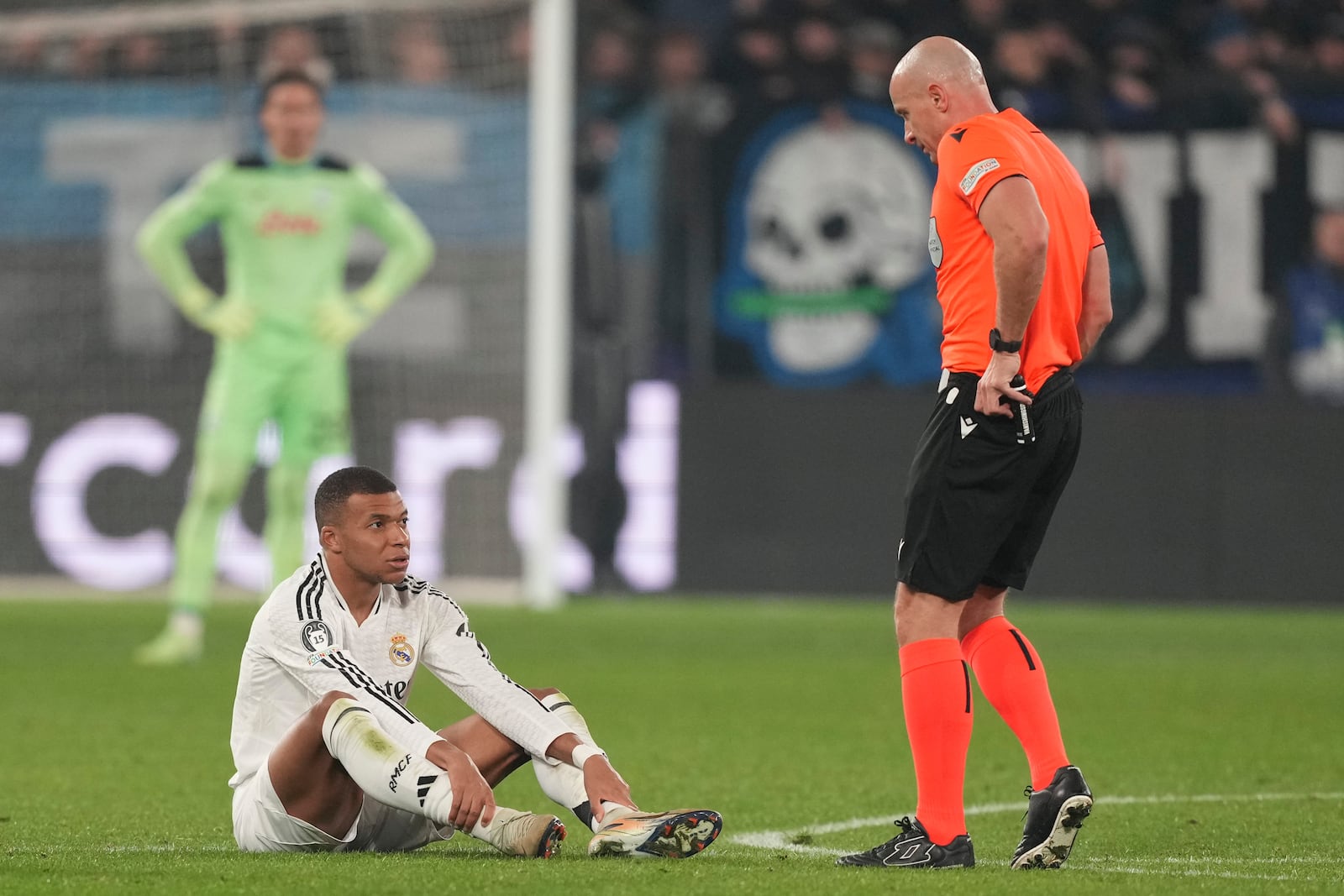 Real Madrid's Kylian Mbappe, left, talks with referee Szymon Marciniak during the Champions League opening phase soccer match between Atalanta and Real Madrid at the Bergamo's stadium, in Bergamo, Italy, Tuesday, Dec. 10, 2024. (AP Photo/Antonio Calanni)