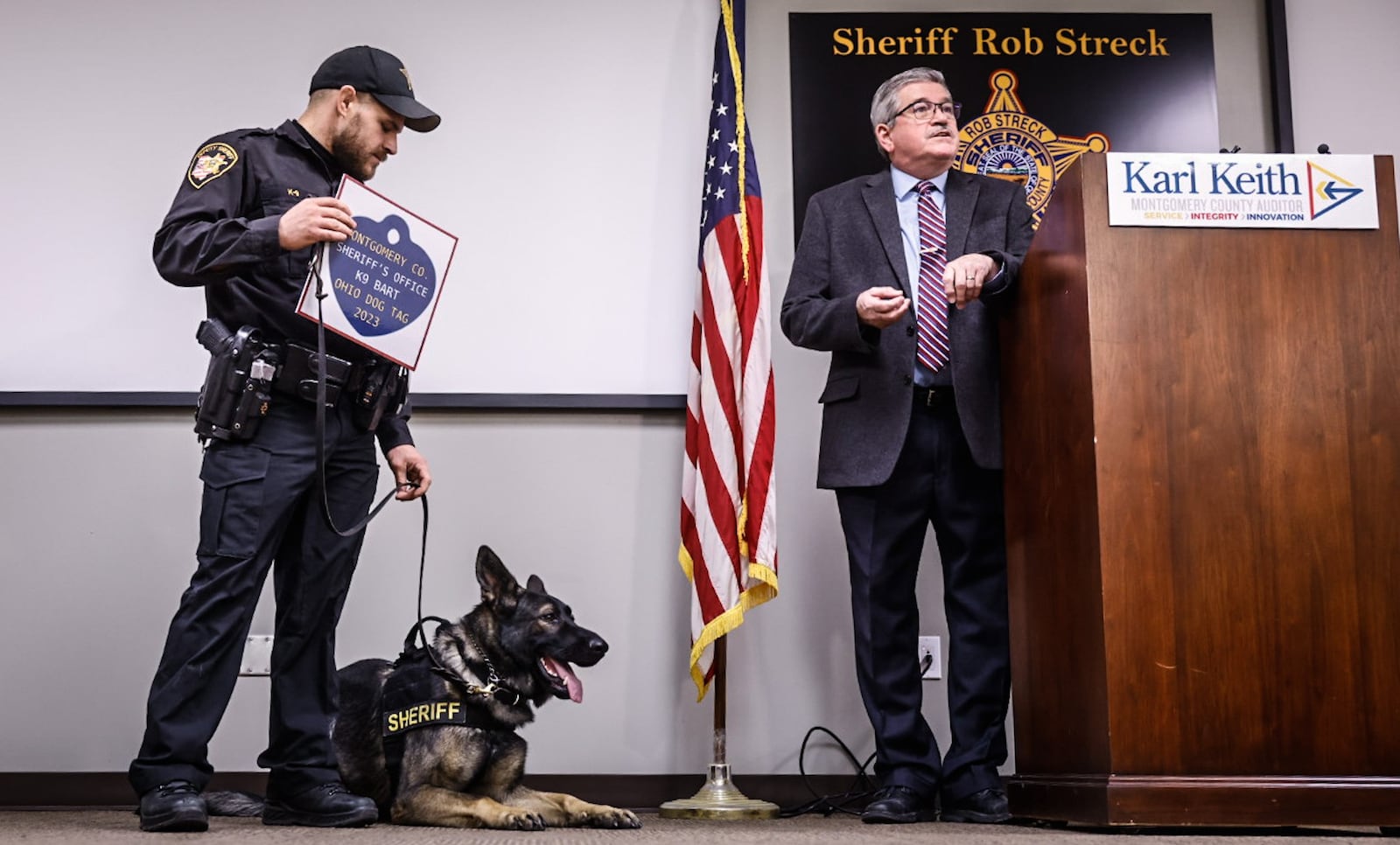 Montgomery County Auditor Karl Keith, right, presented K9 Bart, a 1-year-old German shepherd, and handler, Montgomery County Sheriff's deputy Jesse Walker, with Bart's first dog license on Thursday, Dec. 1, 2022, at the Jefferson Twp. substation to kick off the sale of dog licenses. 2023 dog licenses are on sale through Jan. 31 at www.mcohio.org/dogs. JIM NOELKER/STAFF