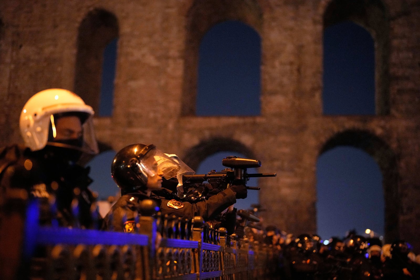 An policeman uses an anti riot rifle to disperse people during a protest against the arrest of Istanbul's Mayor Ekrem Imamoglu in Istanbul, Turkey, Friday, March 21, 2025. (AP Photo/Emrah Gurel)