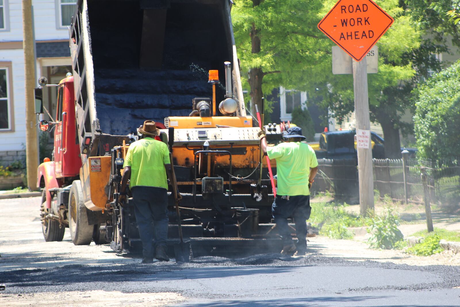 Crews lay down asphalt in the South Park neighborhood on Friday. CORNELIUS FROLIK / STAFF