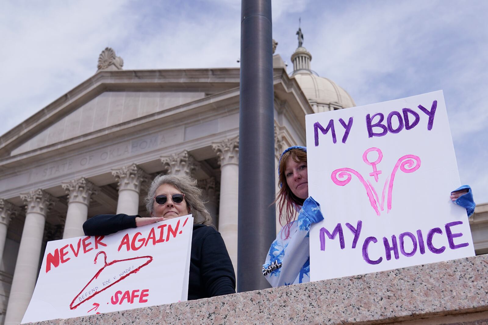 FILE - Dani Thayer, left, and Marina Lanae, right, both of Tulsa, Okla., hold pro-choice signs at the state Capitol, Wednesday, April 13, 2022, in Oklahoma City. (AP Photo/Sue Ogrocki File)