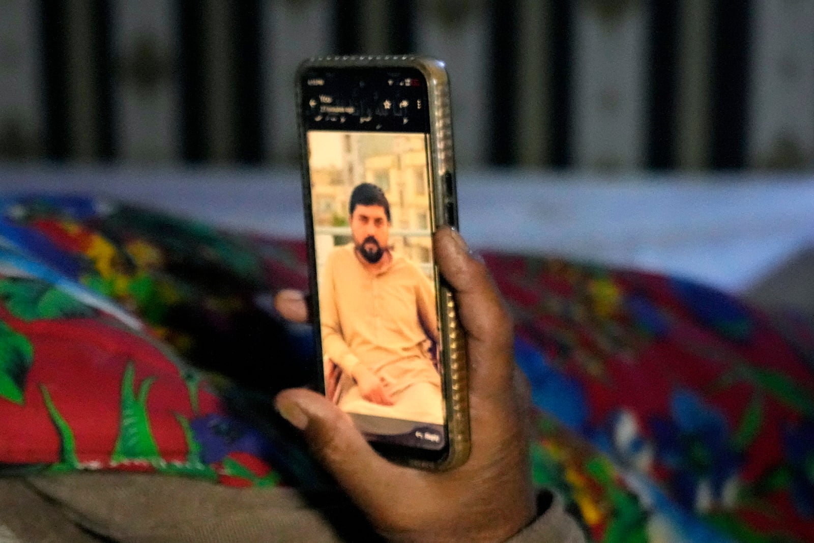 Shaukat Ali shows a picture of his son Atif Shahzad, one of the victims of a migrant boat that capsized in the West Africa's Atlantic coastline, on his cell phone at his home, in Jura village, in the Lalamusa district in Pakistan, Friday, Jan. 17, 2024. (AP Photo/K.M. Chaudary)