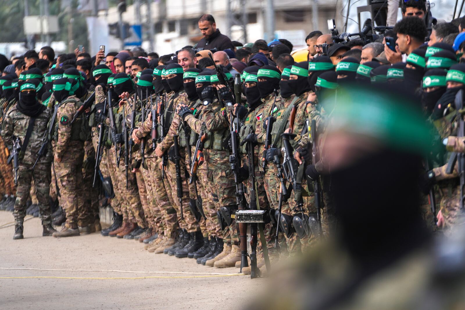 Hamas fighters take up positions ahead of a hostage release in Deir al-Balah, central Gaza Strip, Saturday Feb. 8, 2025. (AP Photo/Abdel Kareem Hana)