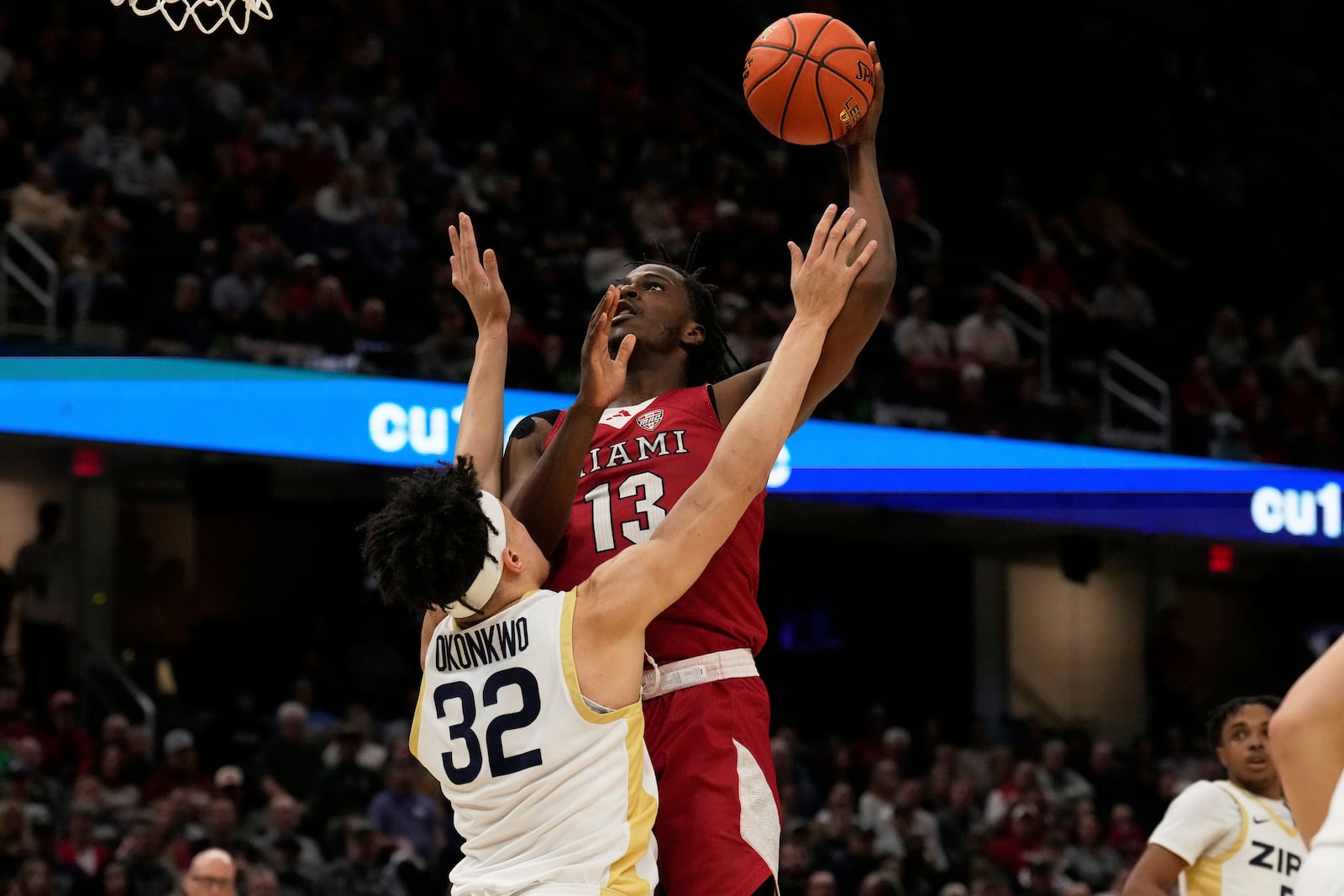 Miami forward Antwone Woolfolk (13) shoots over Akron forward James Okonkwo (32) in the first half of an NCAA college basketball game in the championship of the Mid-American Conference tournament, Saturday, March 15, 2025, in Cleveland, Ohio. (AP Photo/Sue Ogrocki)