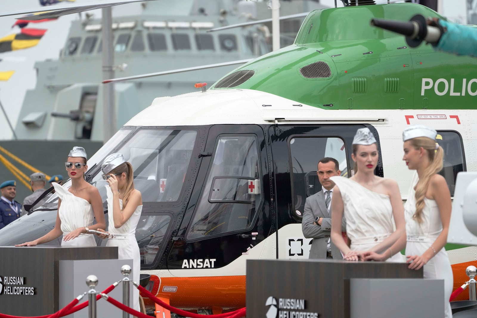 Women stand at a display for Russian Helicopters at the biennial International Defense Exhibition and Conference arms show in Abu Dhabi, United Arab Emirates, Monday, Feb. 17, 2025. (AP Photo/Jon Gambrell)