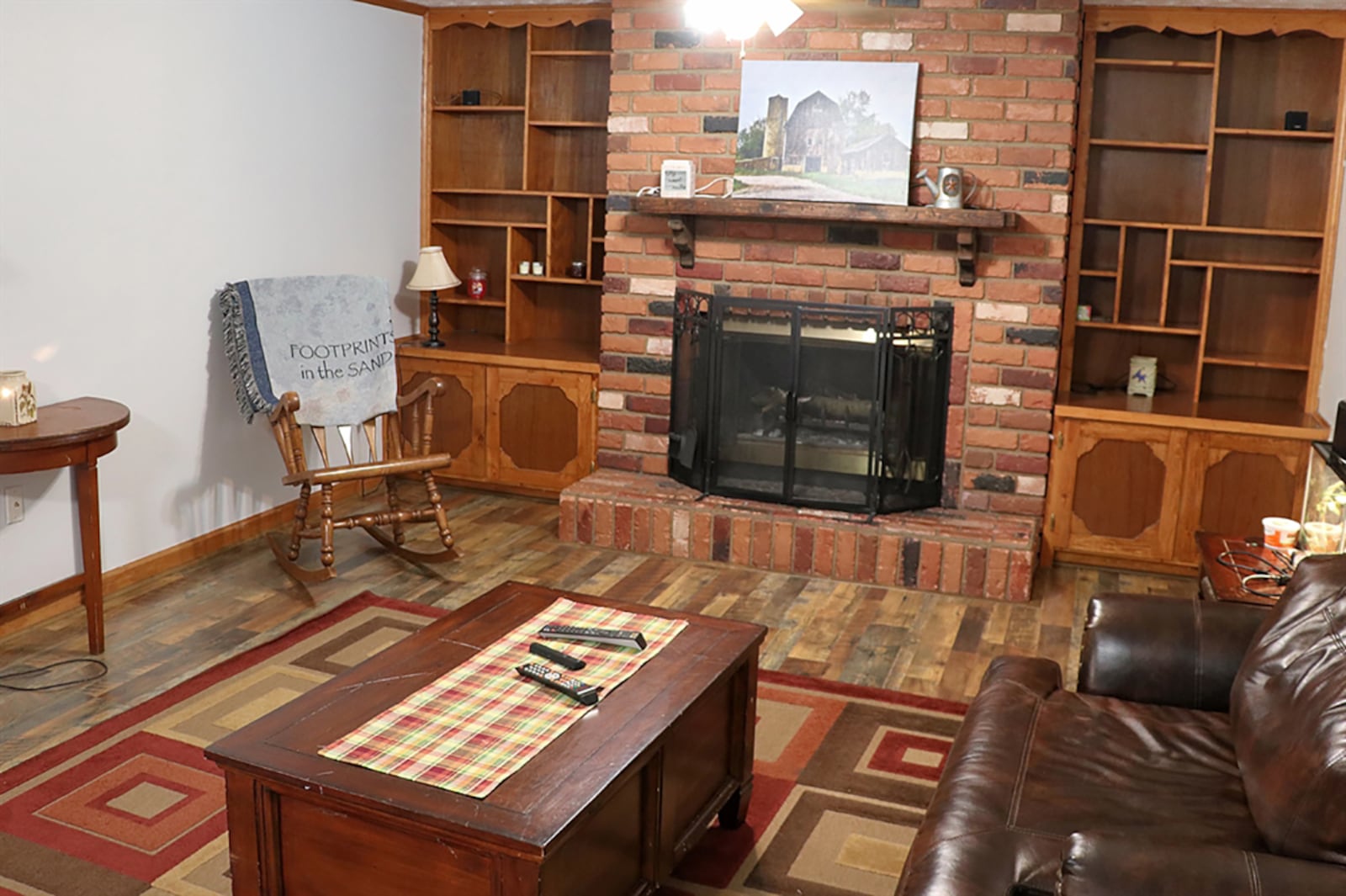 Half of the lower level is a spacious family room with wood-laminate flooring. A brick, wood-burning fireplace is the centerpiece to the room and has a raised brick hearth and wood-beam mantel. CONTRIBUTED PHOTO BY KATHY TYLER