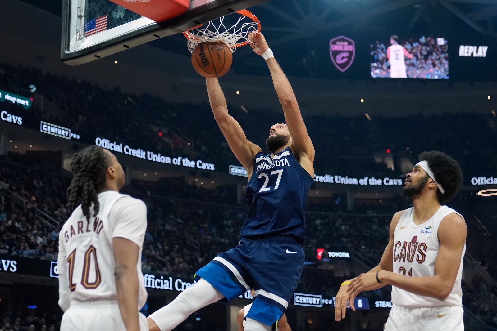 Minnesota Timberwolves center Rudy Gobert (27) dunks between Cleveland Cavaliers guard Darius Garland (10) and center Jarrett Allen, right, in the first half of an NBA basketball game Monday, Feb. 10, 2025, in Cleveland. (AP Photo/Sue Ogrocki)